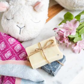 Bars of vegan soap and a stuffed lamb in a cozy setting.