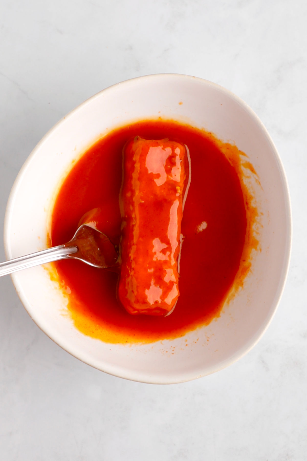 A tofu slice in a buffalo of buffalo sauce.