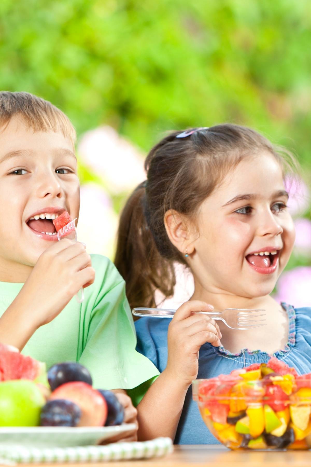 Kids snacking on fresh fruit.