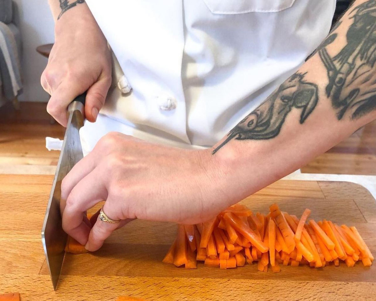 A chef practicing knife skills at The School of Natural Cooking.