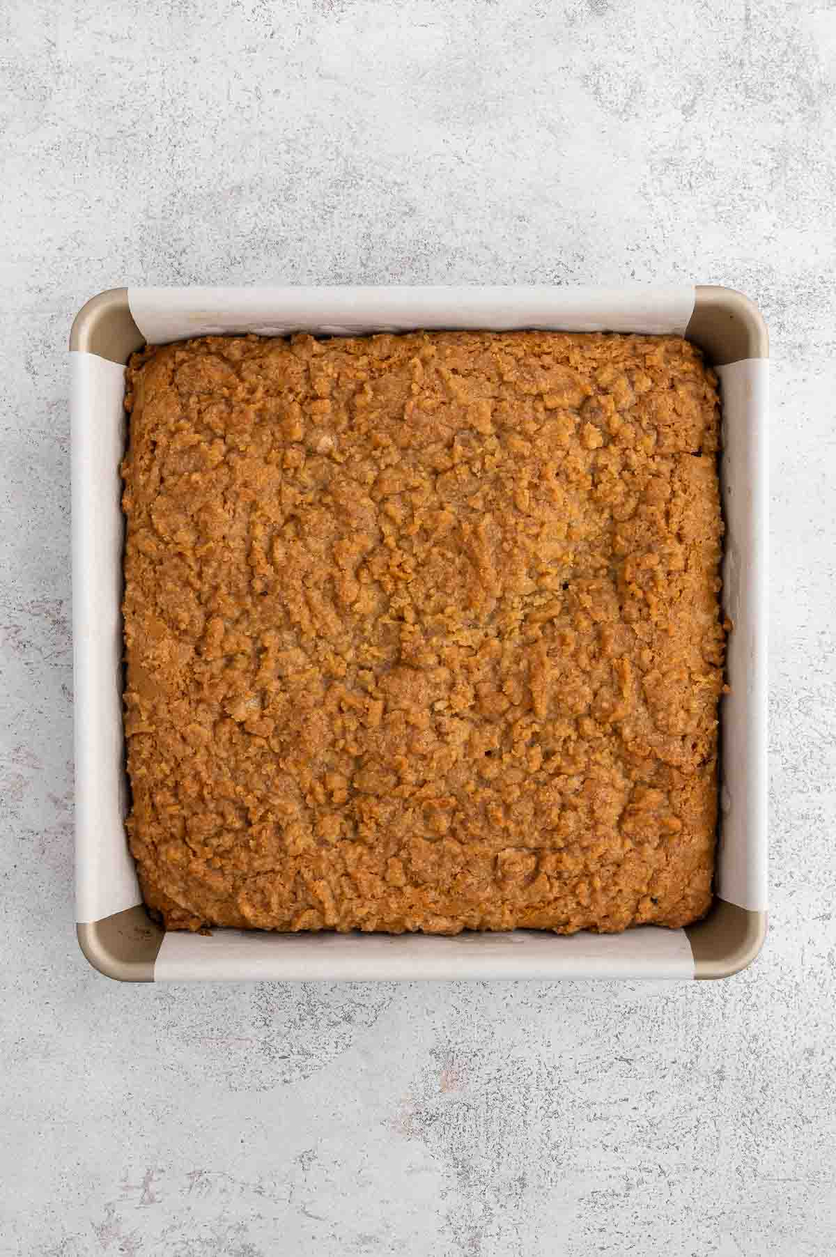 Vegan coffee cake, baked in a parchment-lined baking pan. 