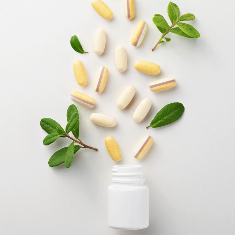 A white bottle with capsules and green sprigs.