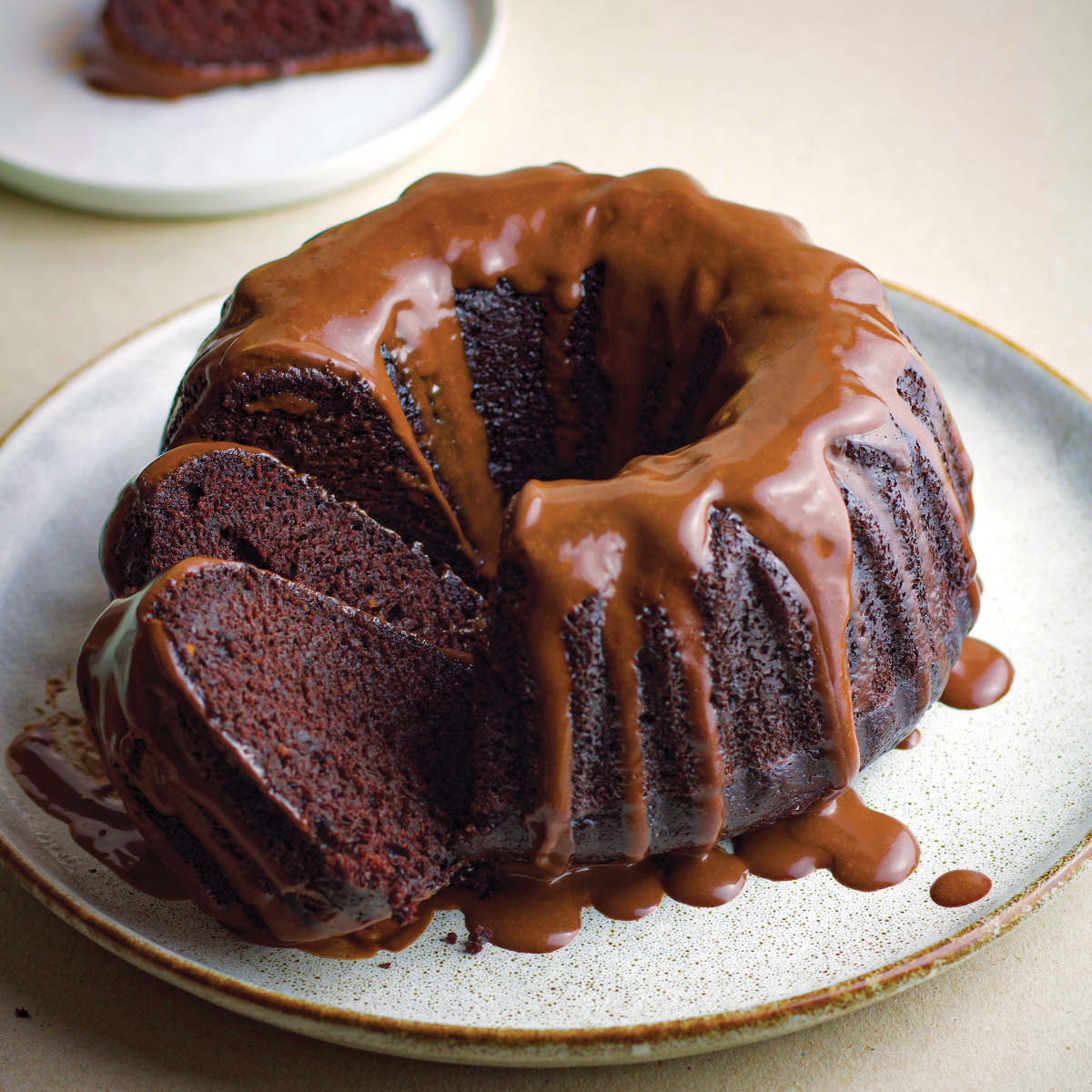 Chocolate vegan bundt cake on a platter, drizzle with vegan chocolate ganache.