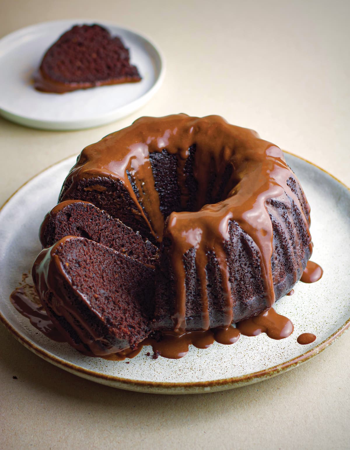 Chocolate vegan bundt cake on a platter, drizzle with vegan chocolate ganache.