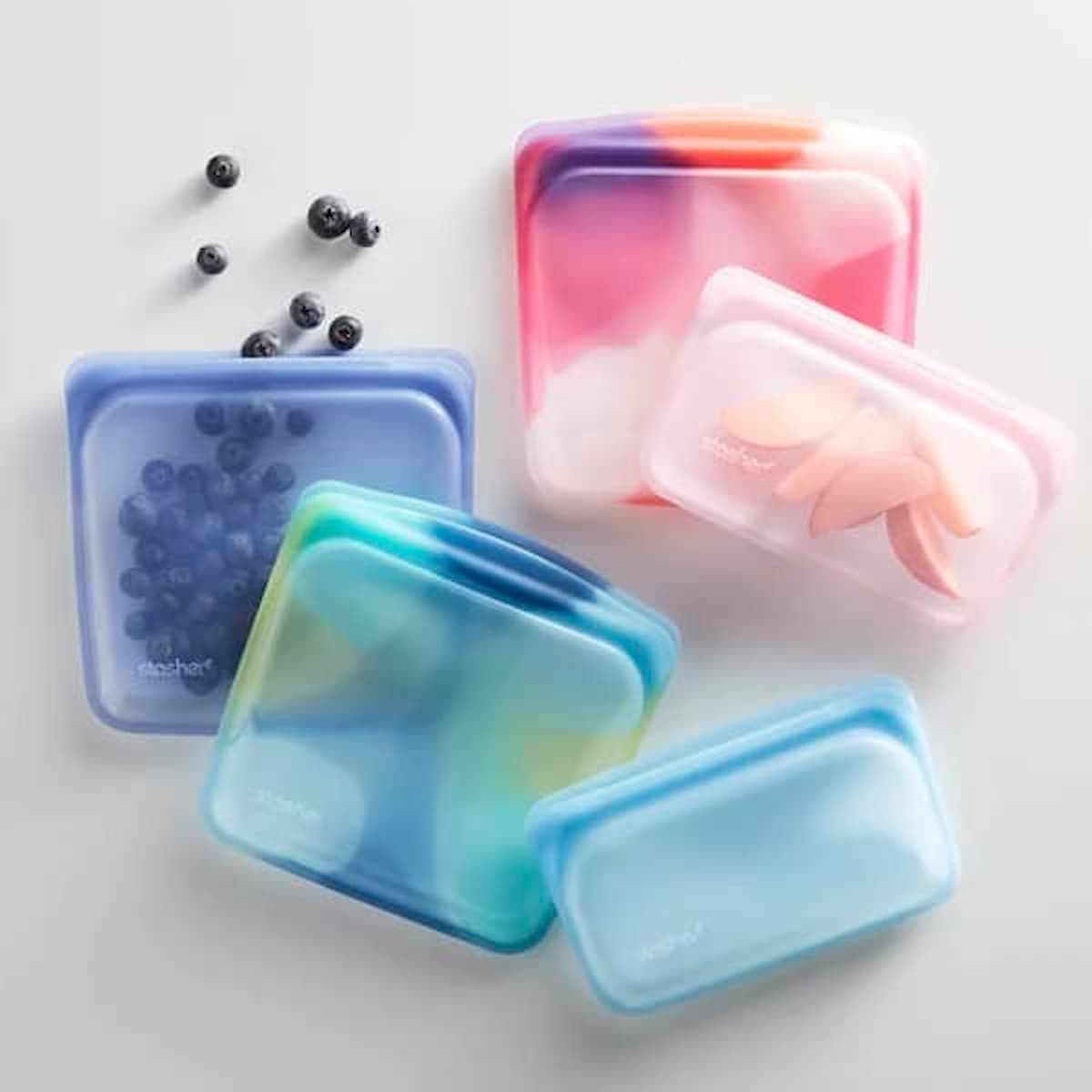 Silicone Stasher bags filled with fresh fruit and veggie snacks.