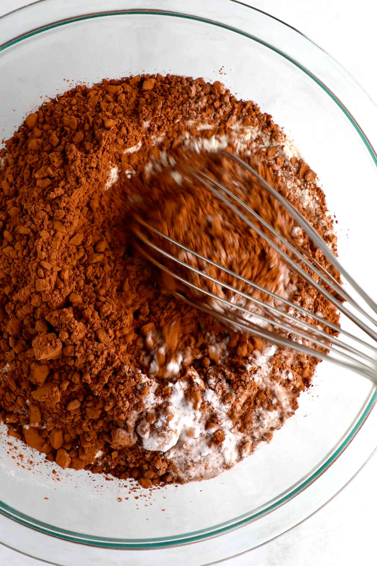 Whisking the dry ingredients for this vegan chocolate cake in a bowl.