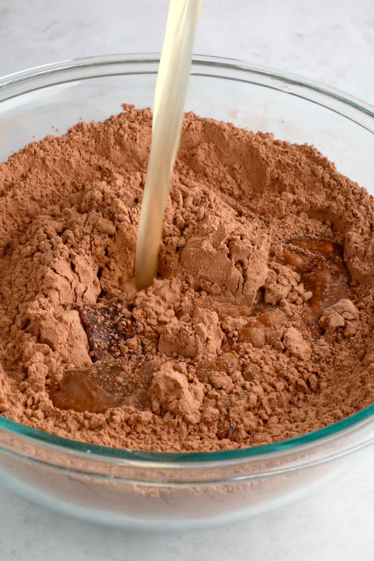 Adding the wet ingredients to the bowl of dry ingredients.