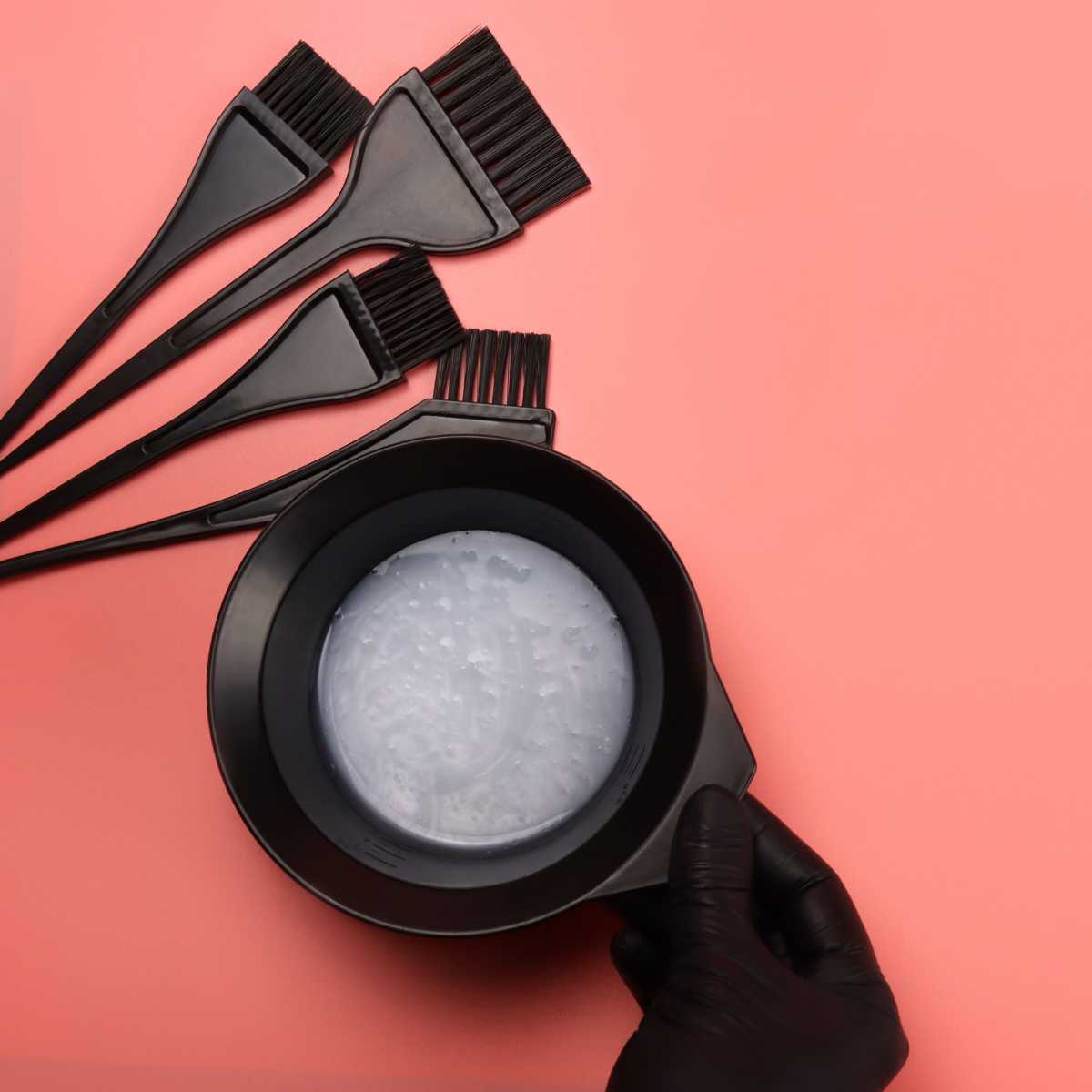 Vegan hair dye in a plastic bowl next to hair dye tools and brushes.