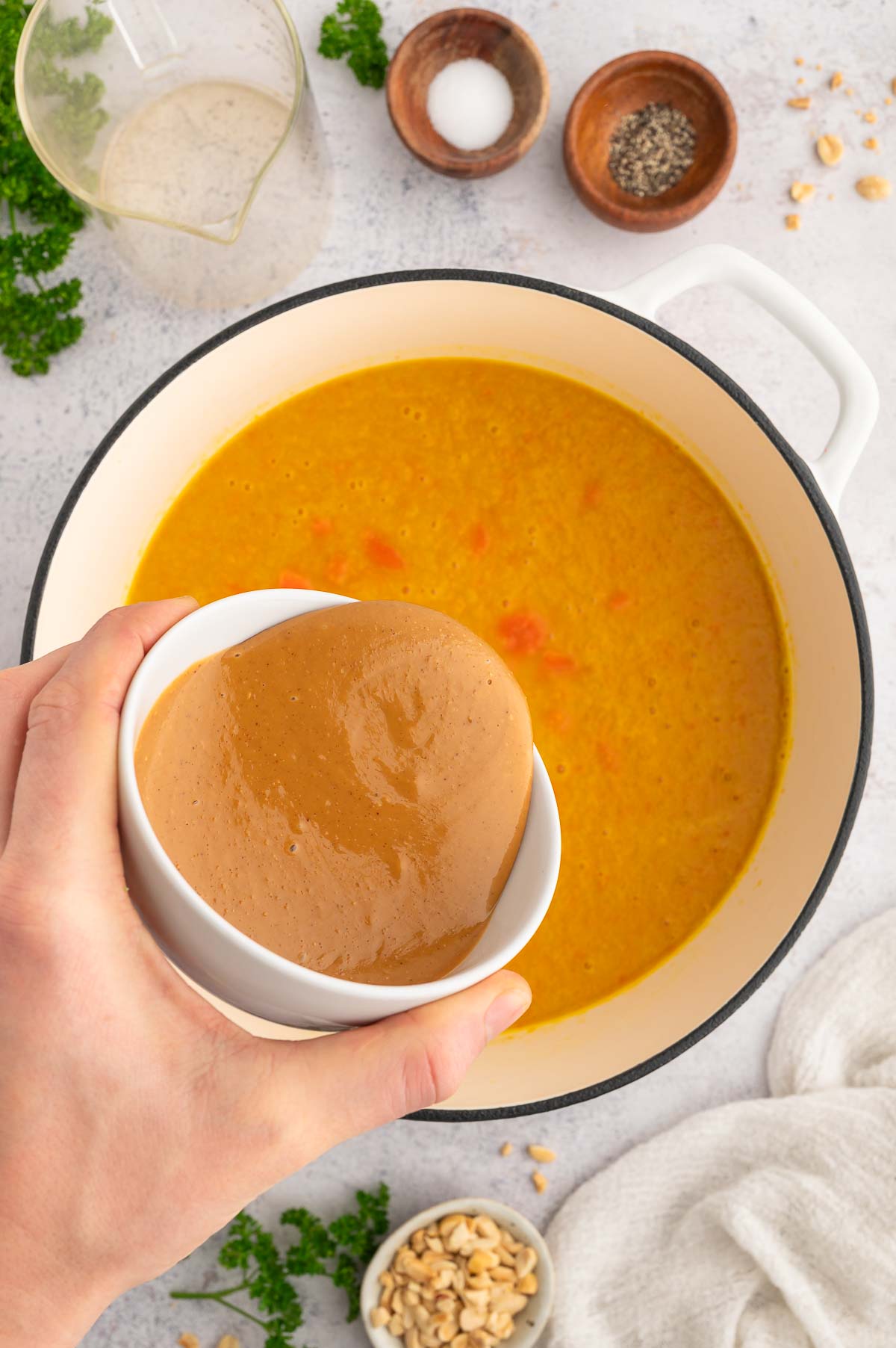 Peanut butter being added to broccoli and peanut butter soup during prep.