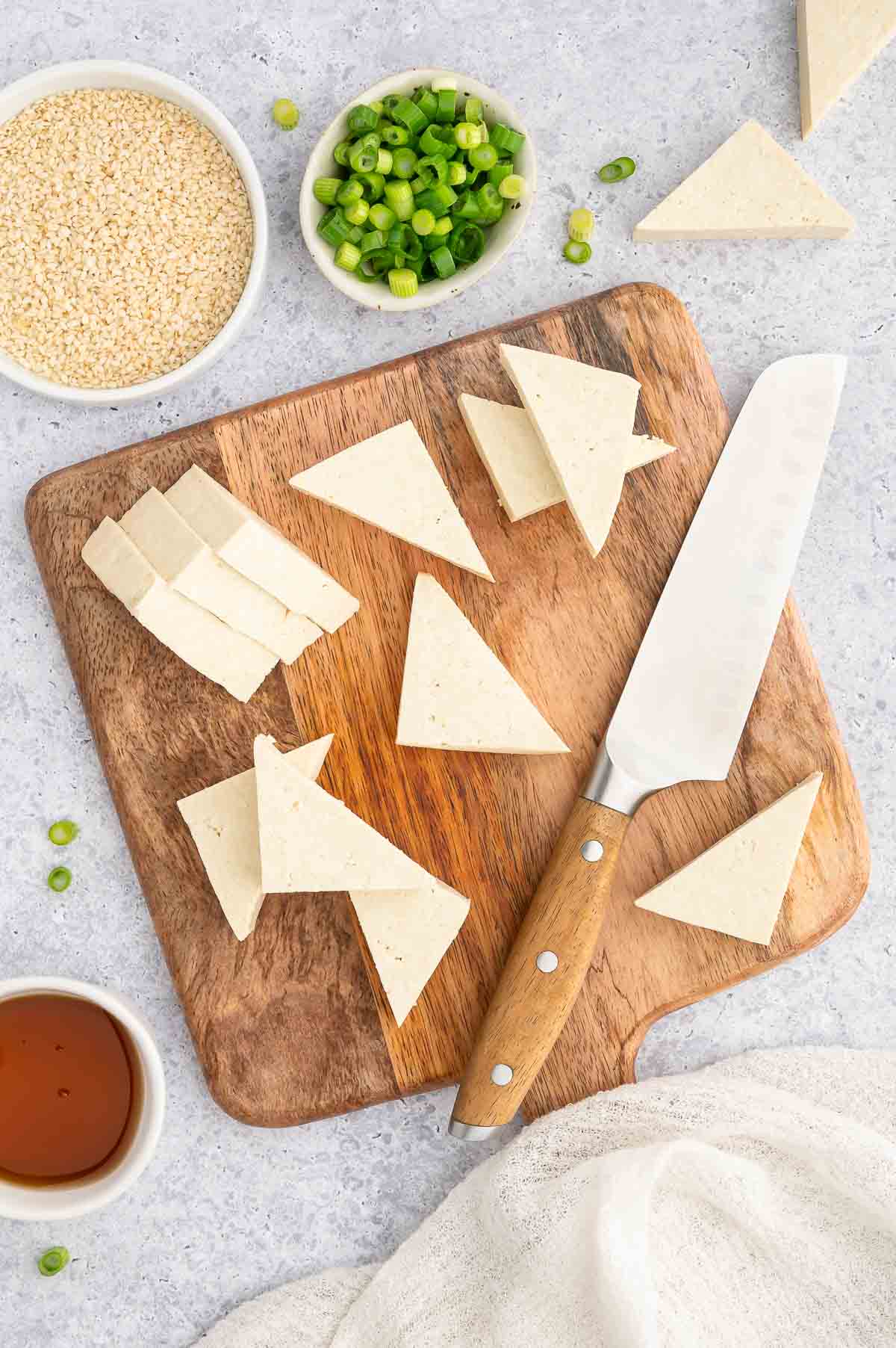 Sliced tofu on a wooden board.