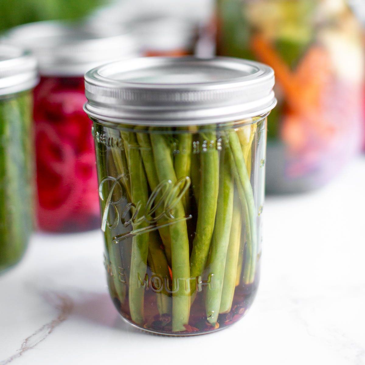 A jar of quick pickled green beans, a great vegan picnic idea.