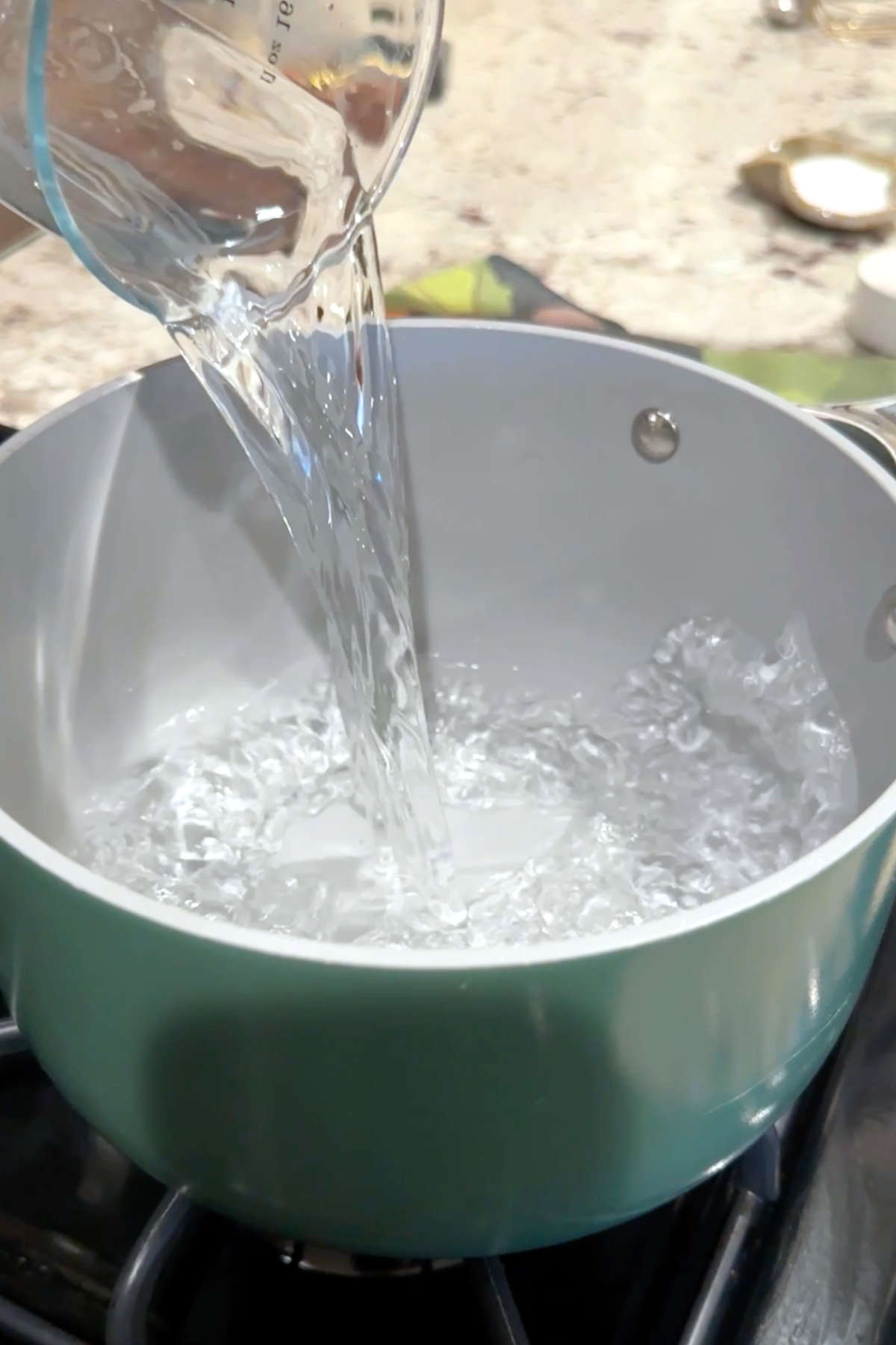 Action shot of liquid being poured into a large stockpot to make pickling brine.