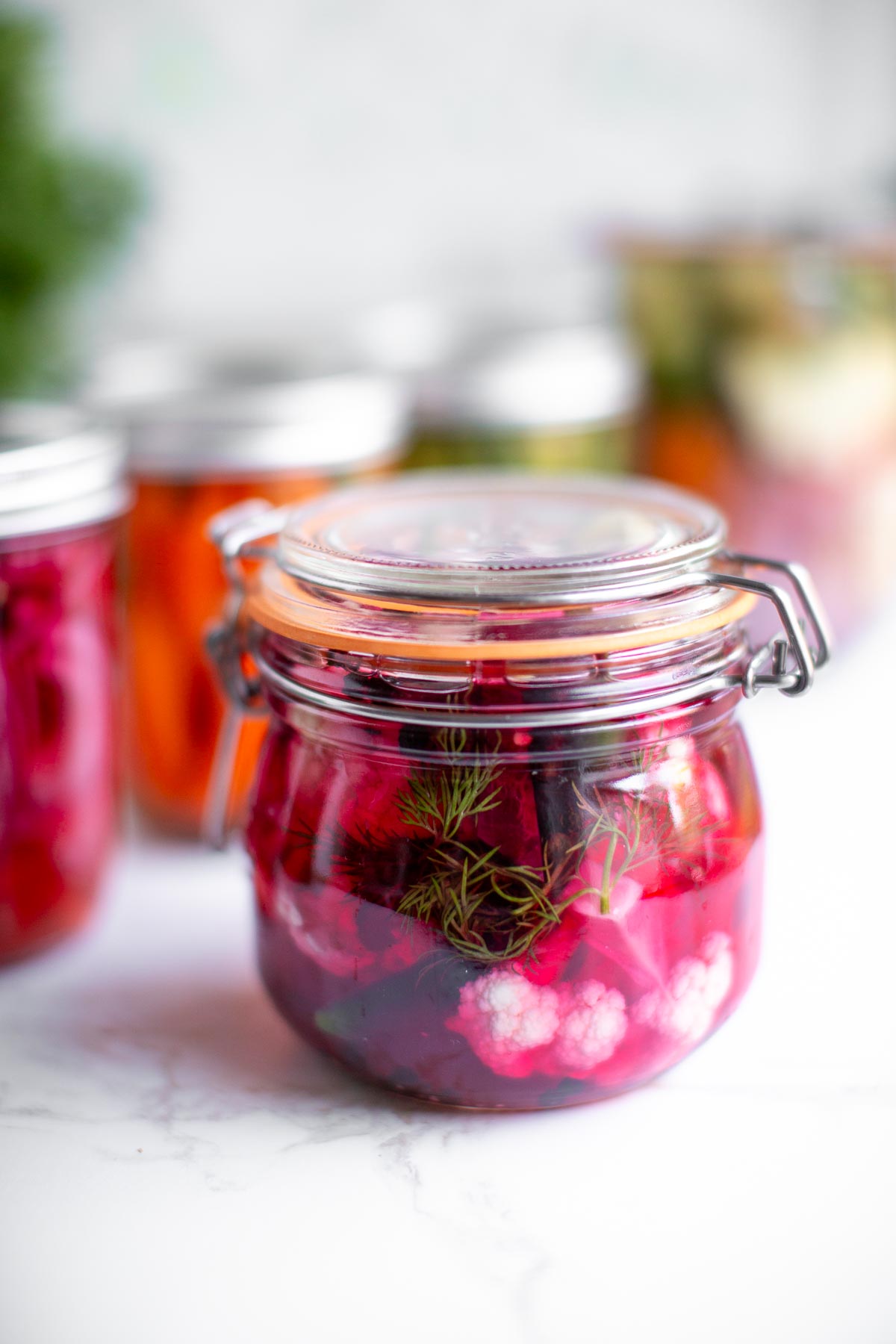 Quick pickled cauliflower in a jar with seasonings and brine.