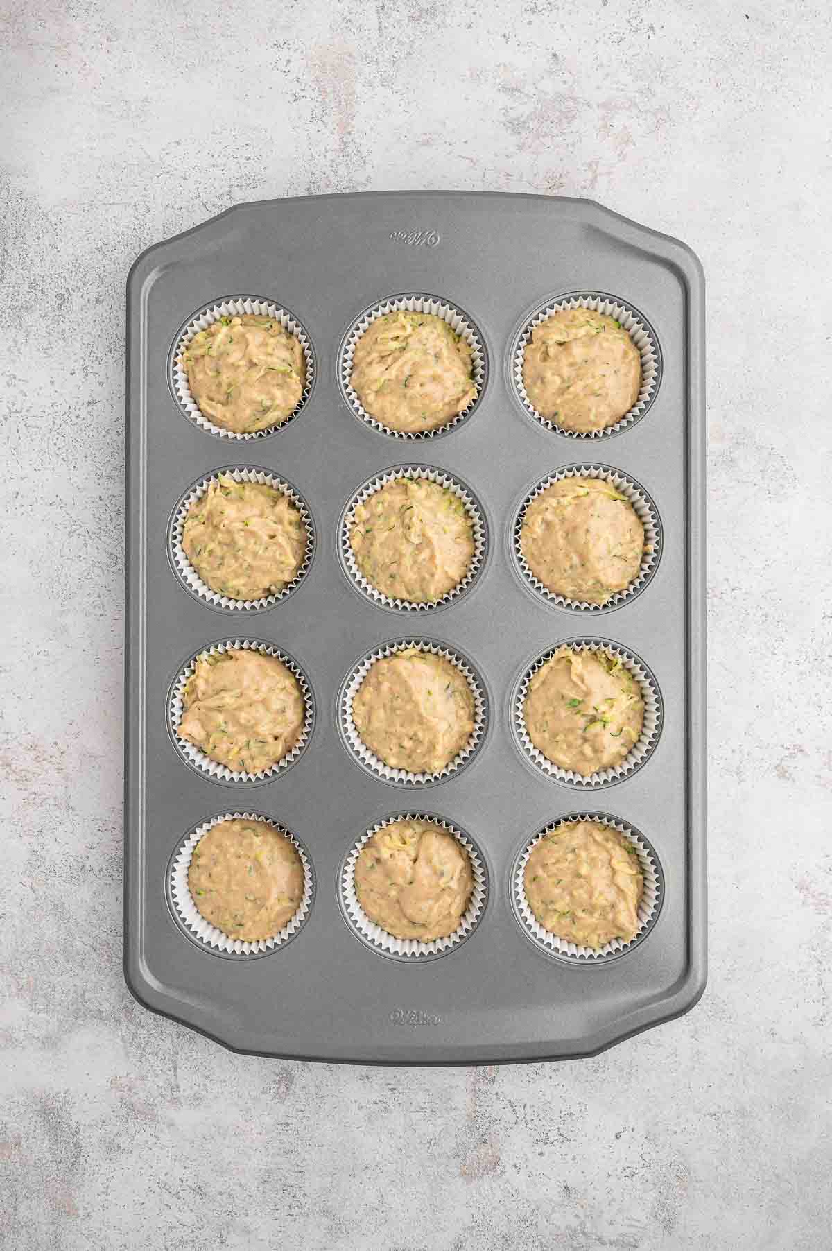 Vegan zucchini muffin batter in a baking tin.