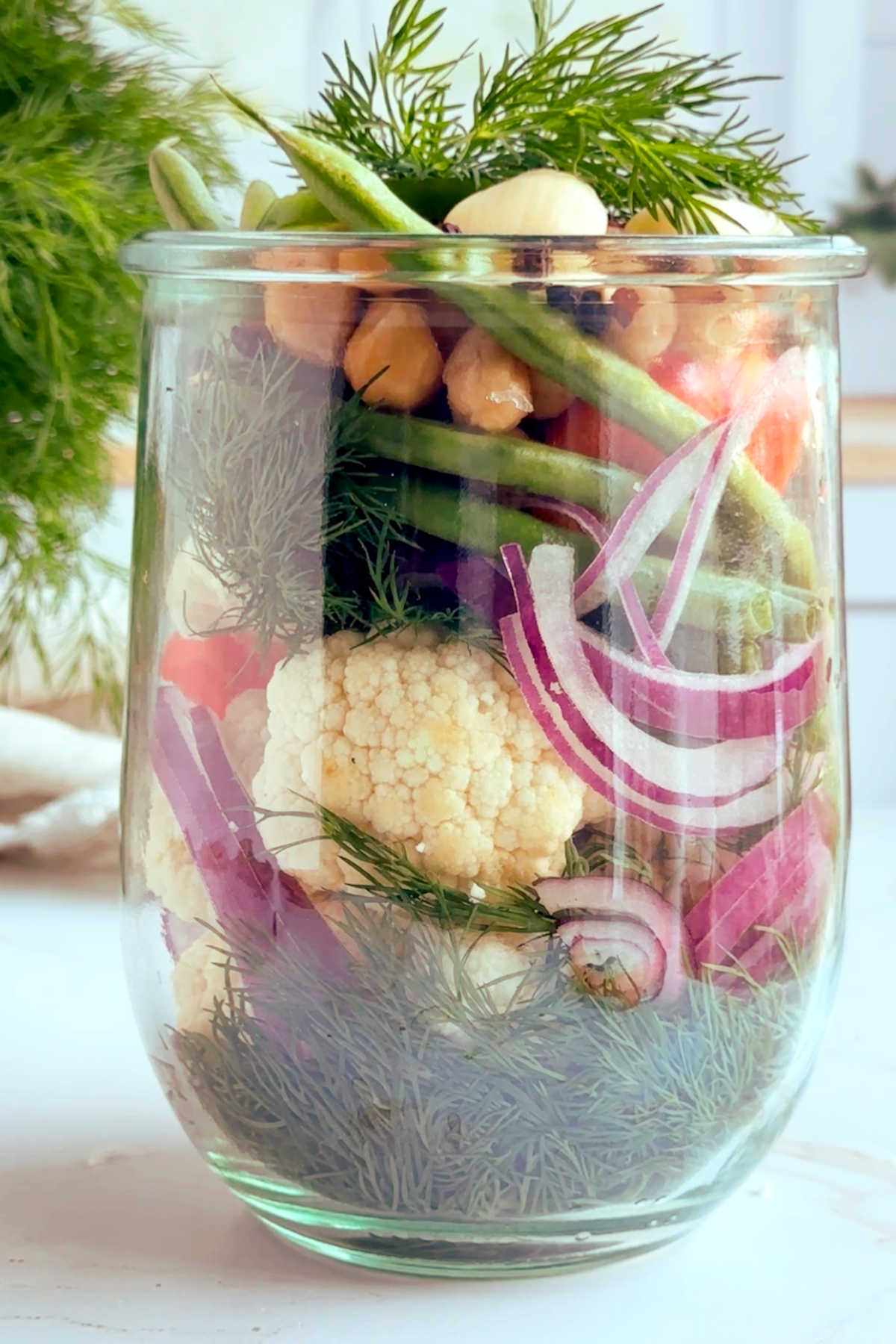 Mixed vegetables packed into a glass jar.