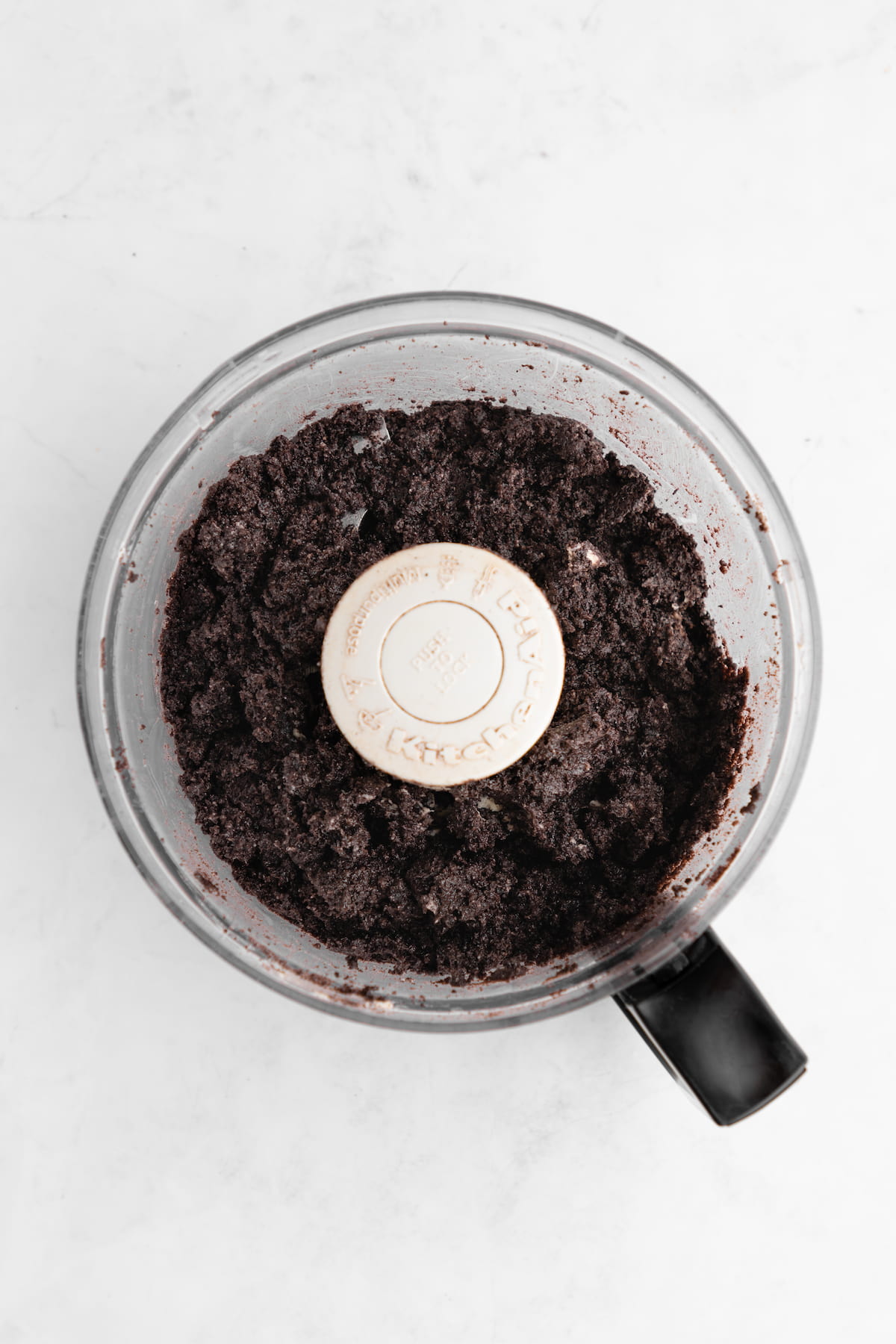 The blended oreo pie crust dough in a food processor.