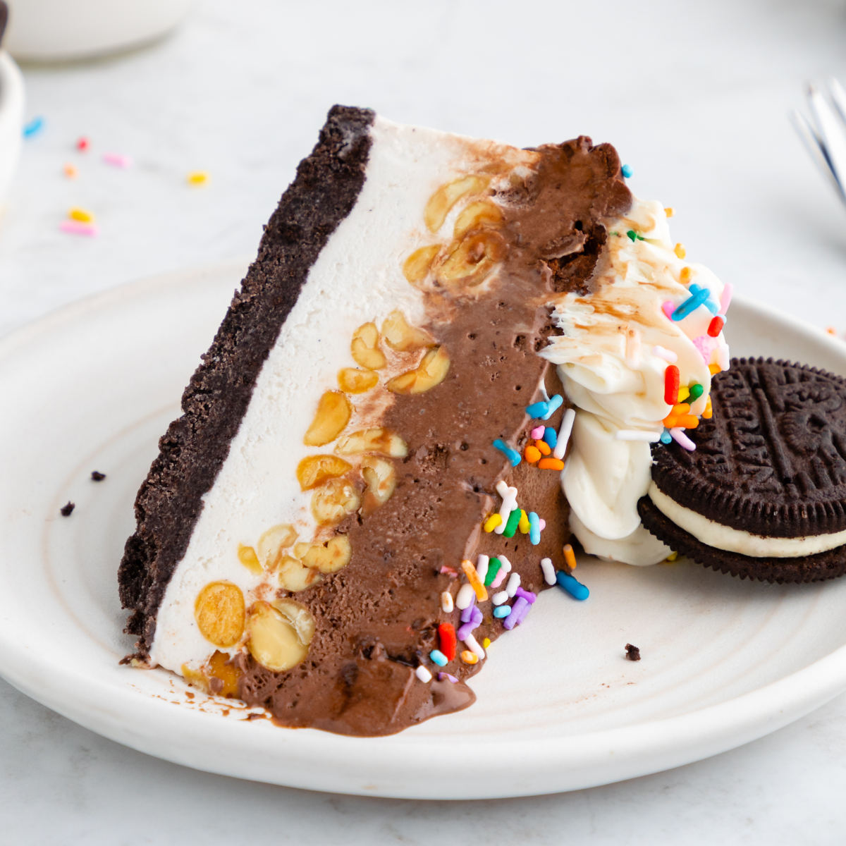 A slice of ice cream cake made with oreo pie crust.