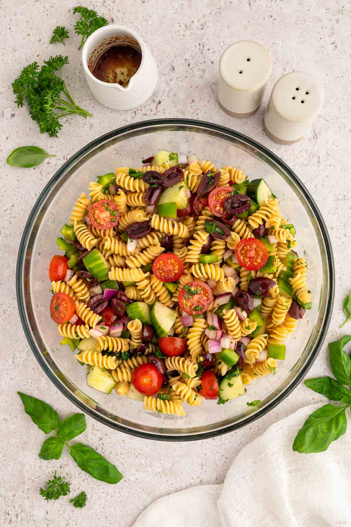 The vegan pasta salad ingredients all mixed together in a large mixing bowl.