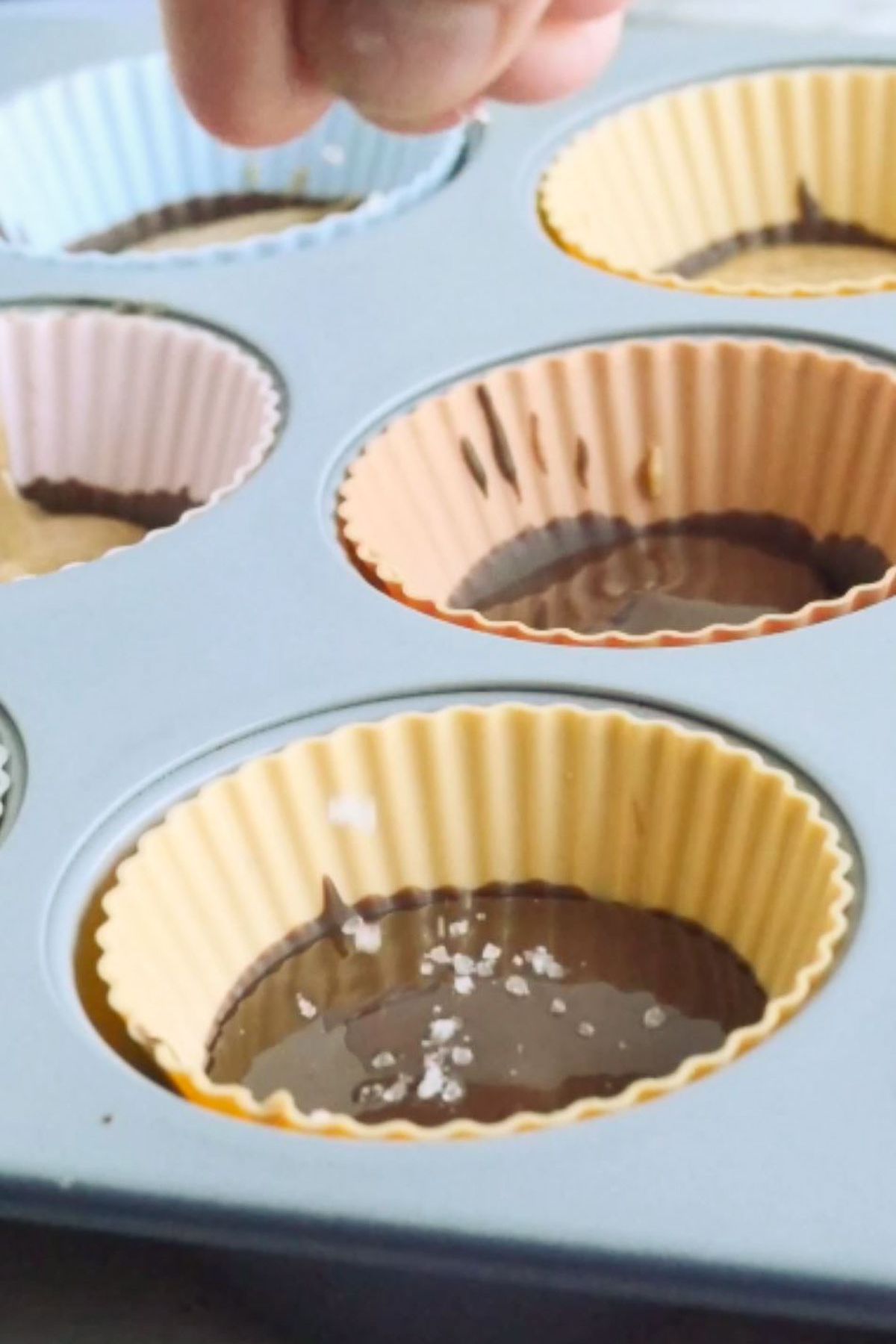 A vegan peanut butter cup being sprinkled with sea salt.