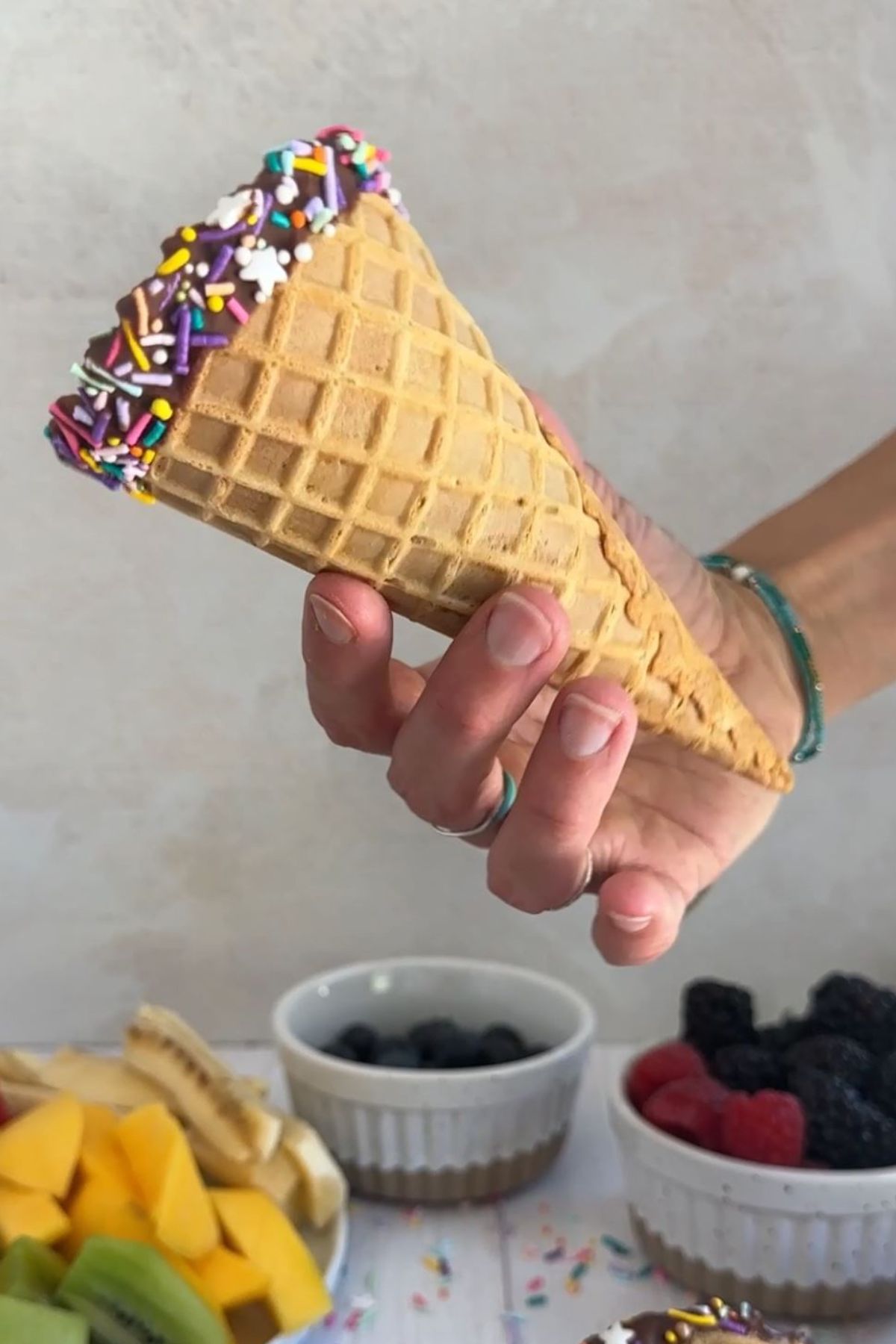 A ice cream cone with chocolate and sprinkles.