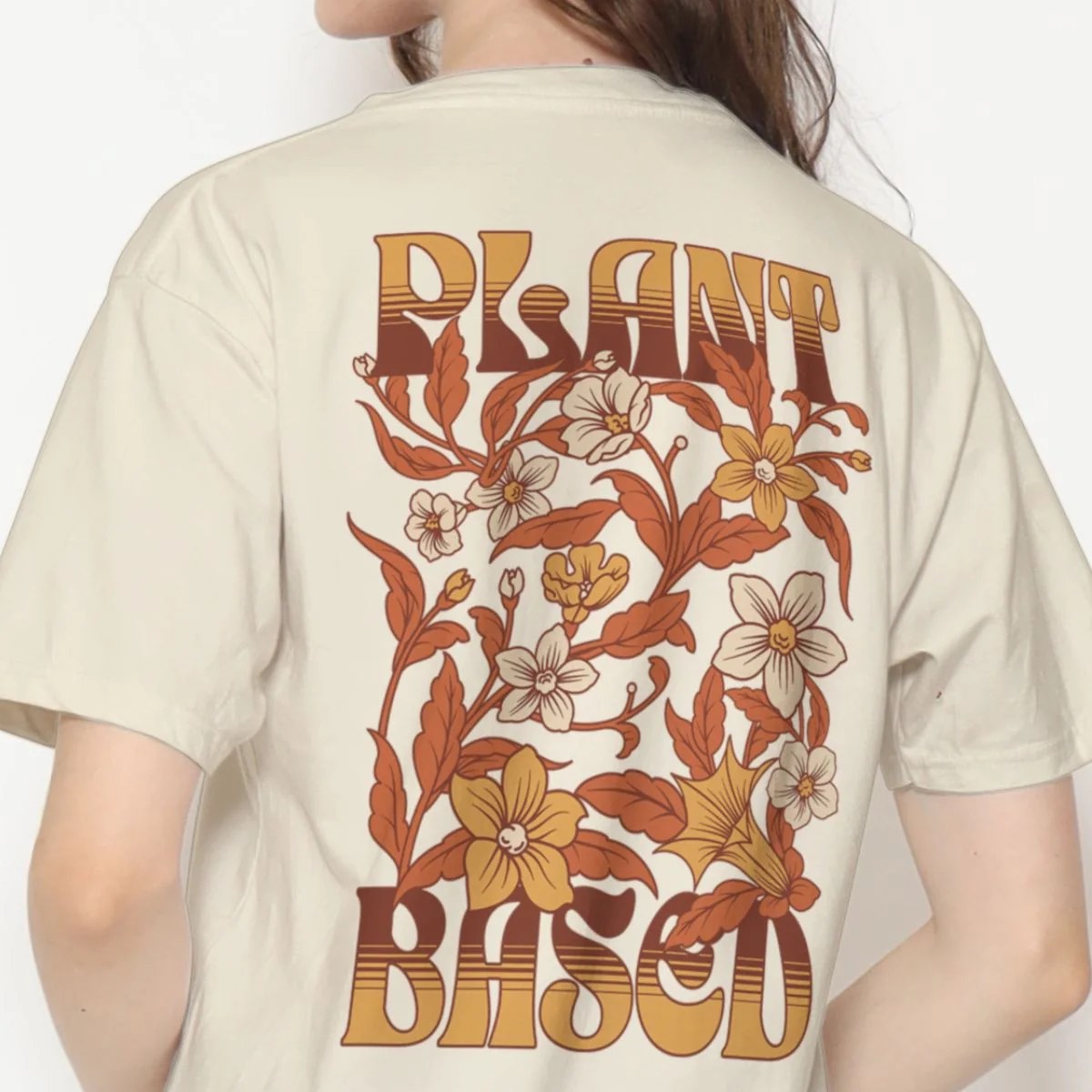 Woman wearing a t-shirt that says Plant Based on the back with a floral design from Worn Out Vegan clothing company.