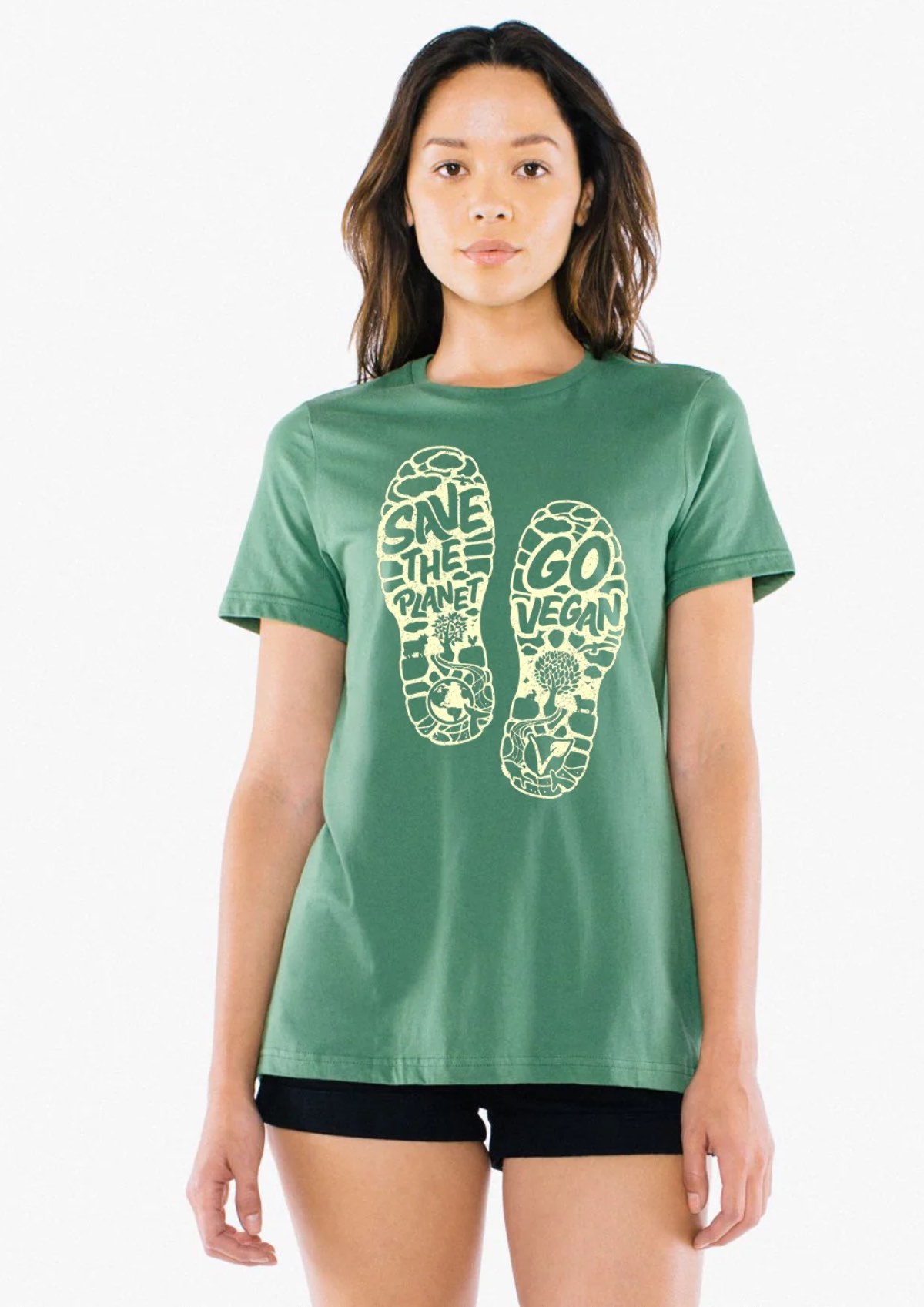 A tall woman wearing a shirt with two footprints that say "Save the planetโgo vegan!"