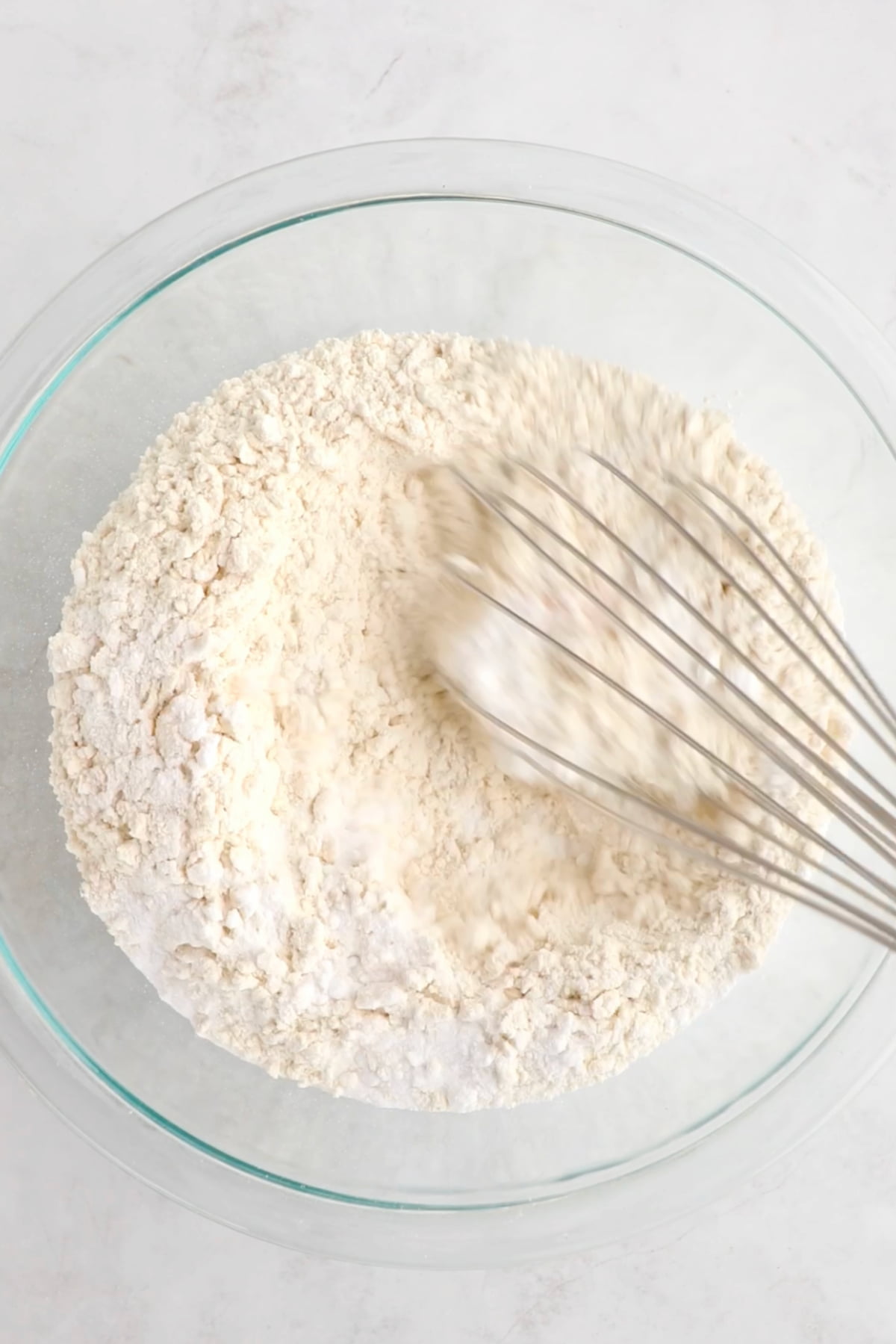 Dry ingredients for this vegan birthday cake being whisked in a mixing bowl.