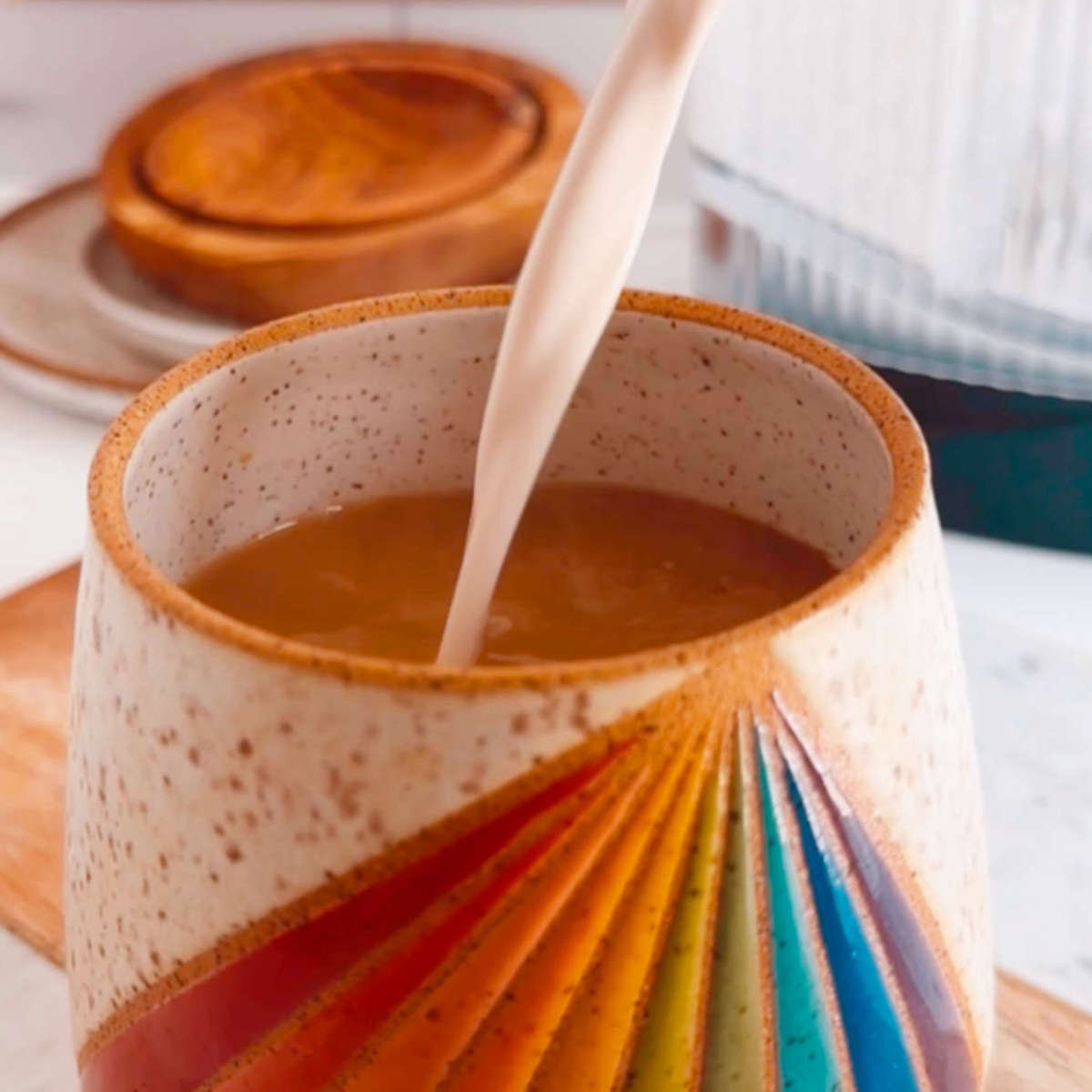 Vegan coffee creamer being poured into a mug of coffee.
