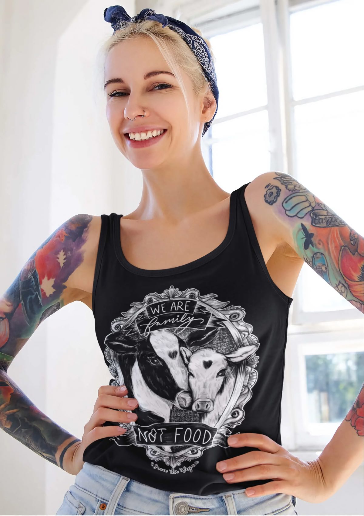 A woman wearing a vegan shirt from Viva La Vegan clothing company with cows that says "we are family, not food."