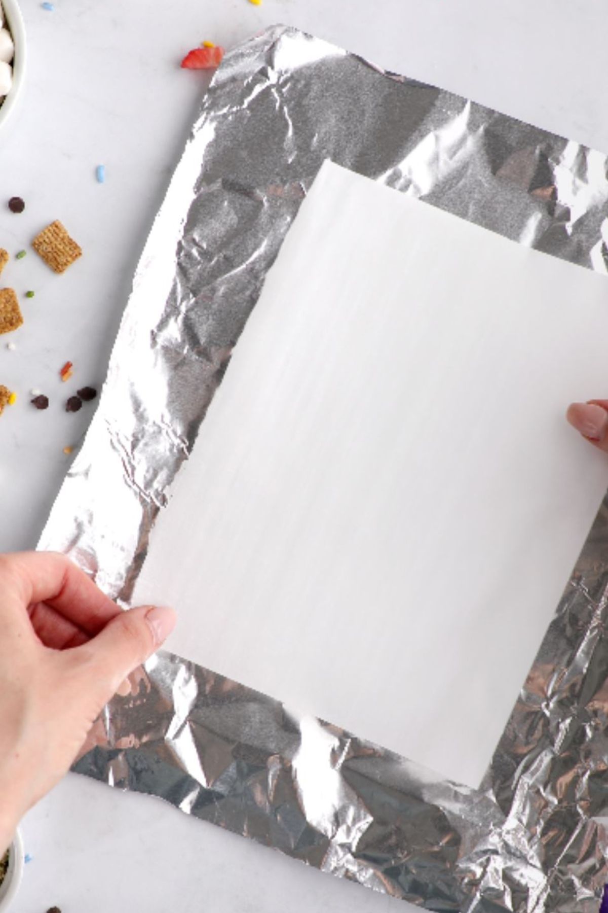 A piece of foil with a piece of parchment paper over the top.