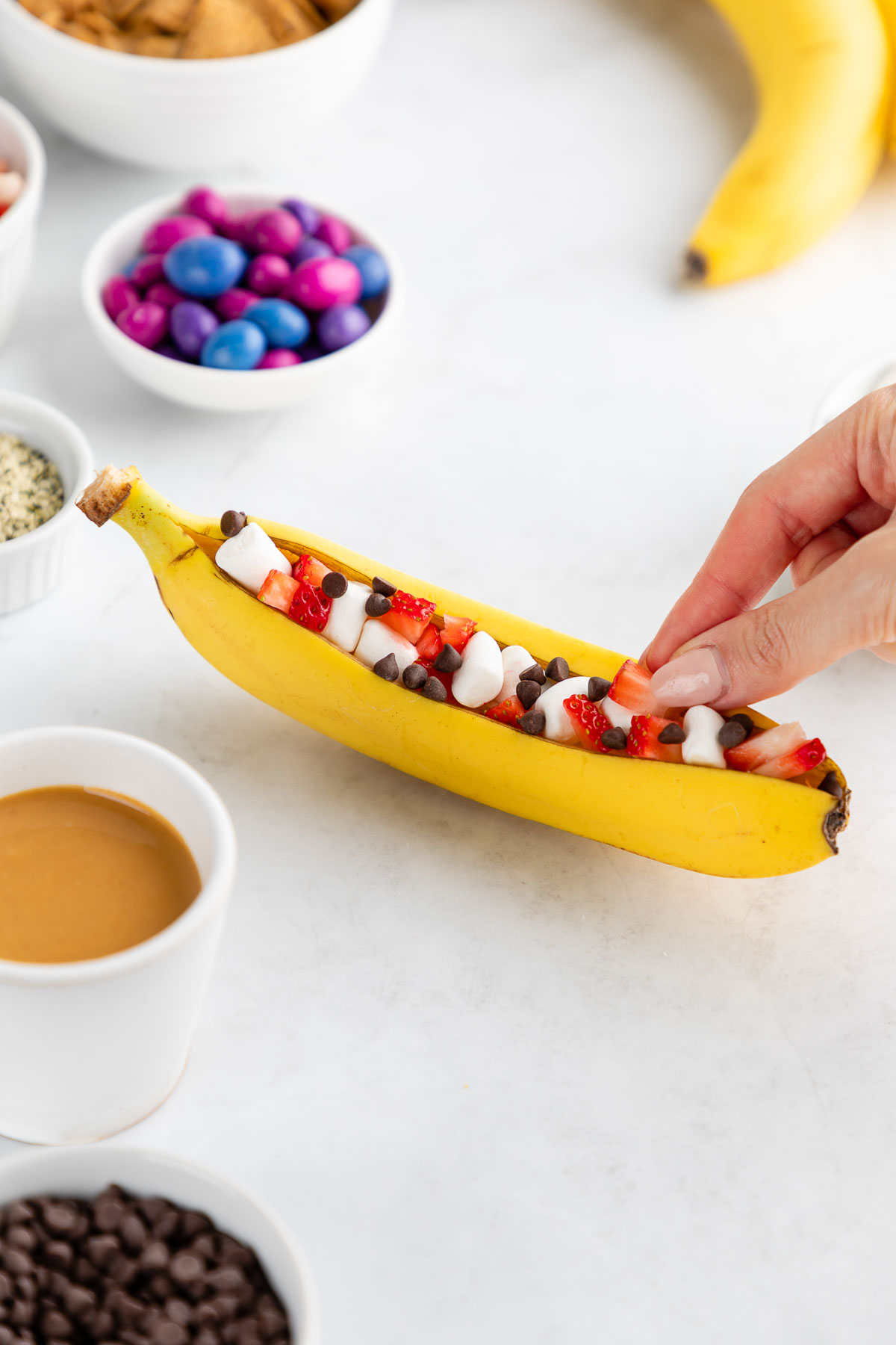 A campfire banana boat filled with strawberries and vegan chocolate chips.