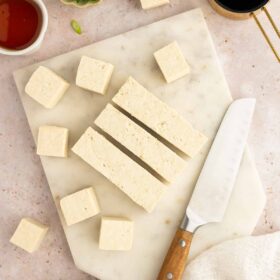 Tofu cubed on a cutting board.