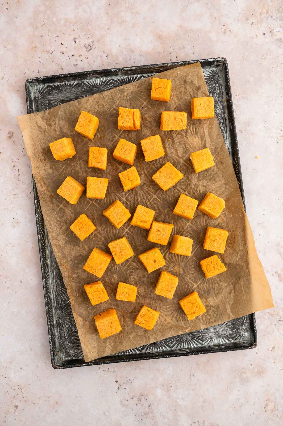 Baked red lentil tofu cubes on a baking sheet.