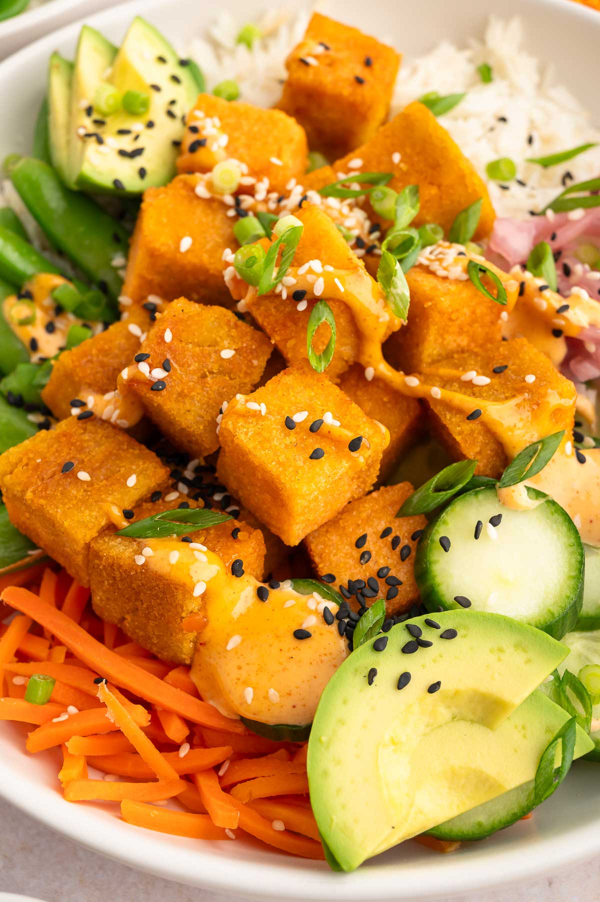 Red lentil tofu cubes in a salad with avocado.