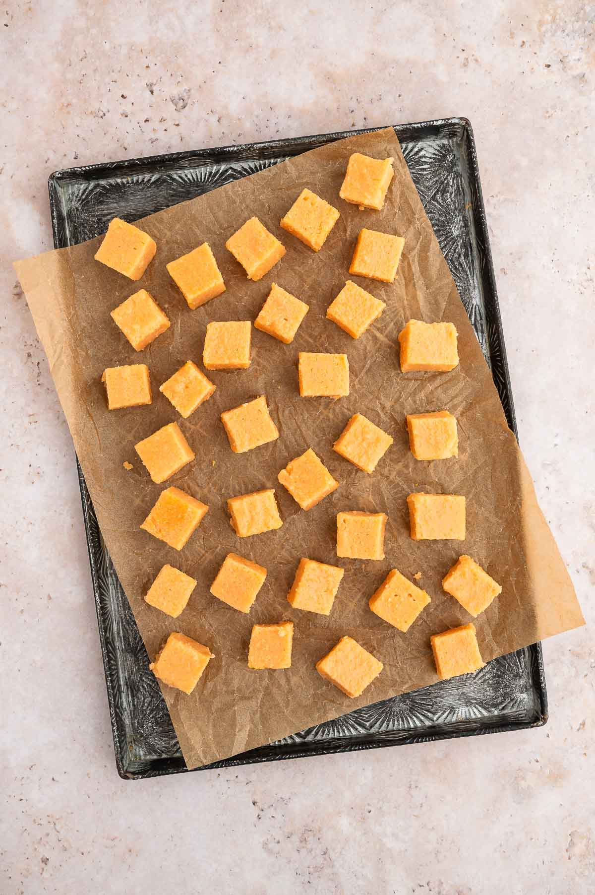Red lentil tofu cubes on a baking sheet.