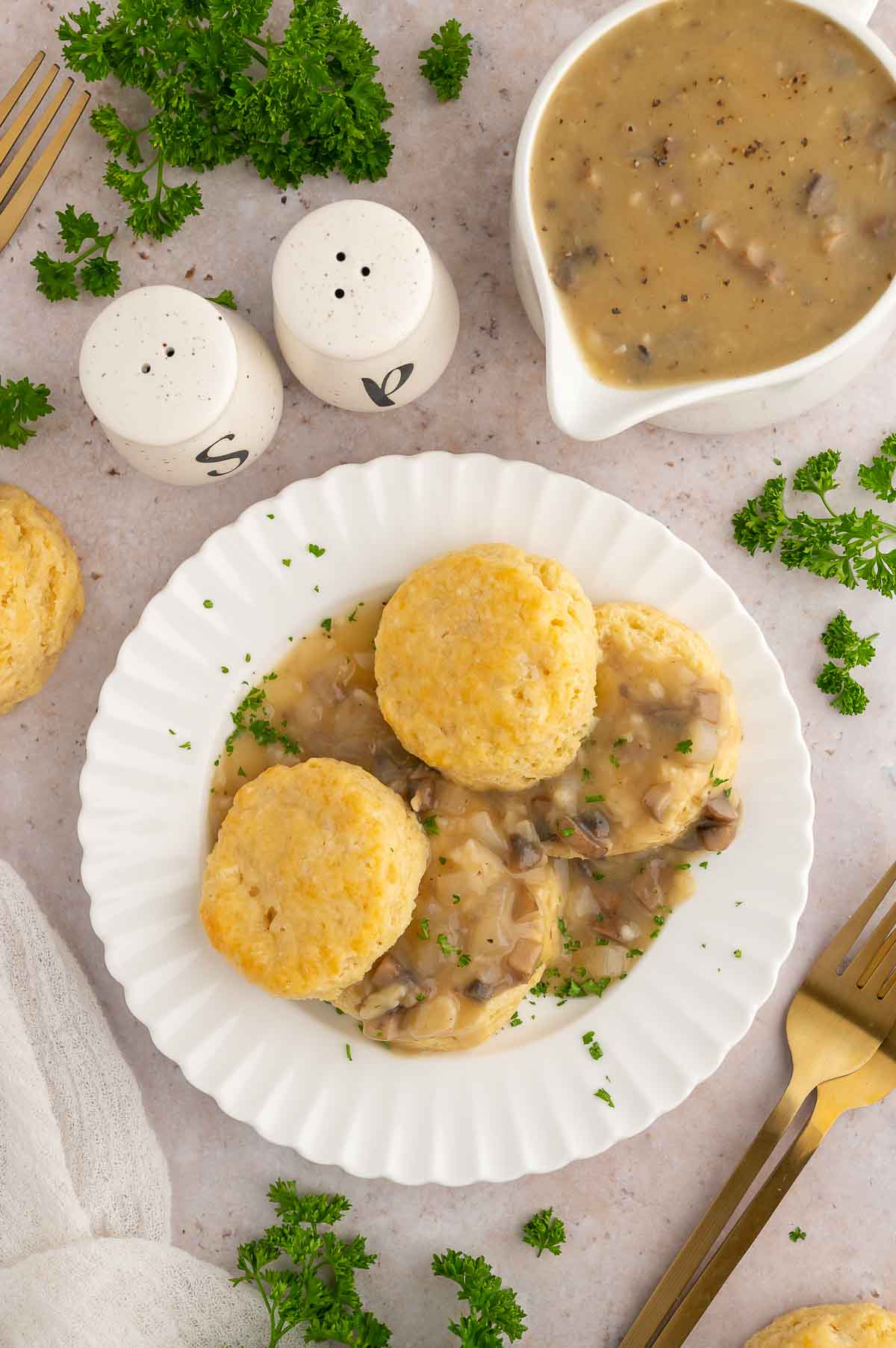 Vegan biscuits and gravy on a plate with a gravy boat.