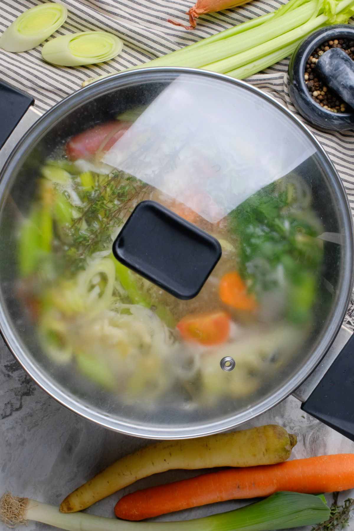 Vegetable scraps in a pot with a lid.