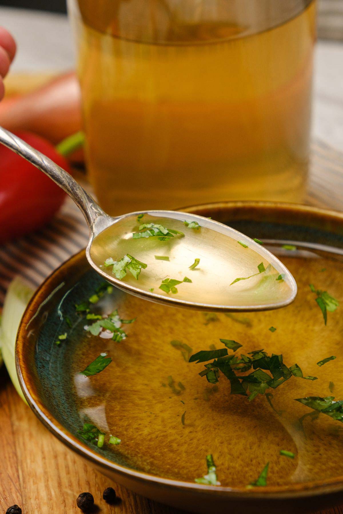 A bowl of homemade vegan broth with a spoon.