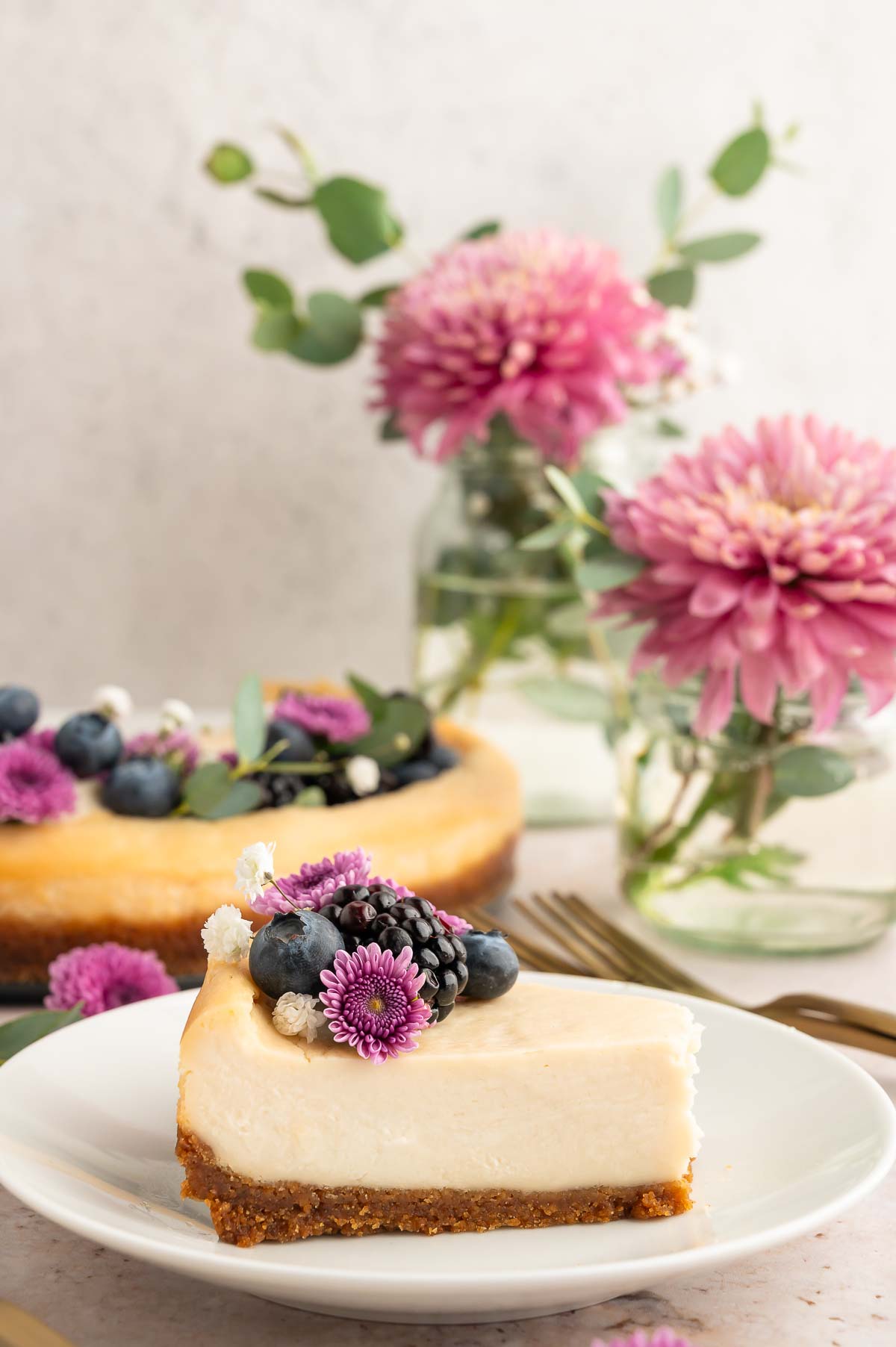 A slice of vegan cheesecake with a vegan graham cracker crust on a serving plate.