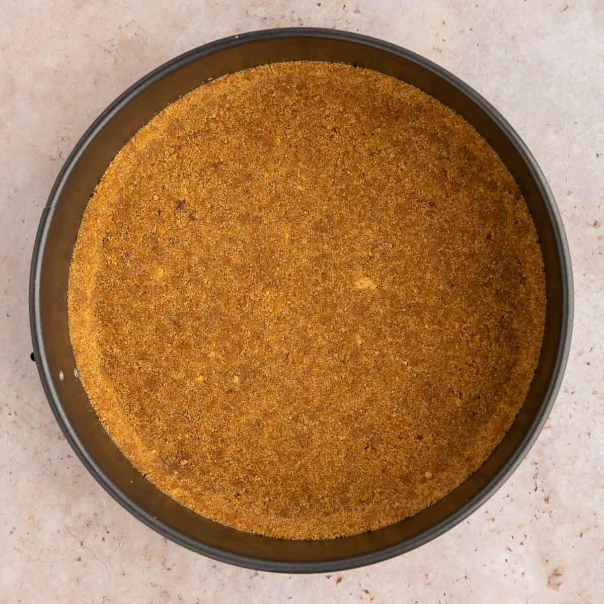 Vegan graham cracker crust in a springform pan.