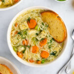 A large bowl of vegan chicken noodle soup with tofu, carrots, celery, and spaghetti.