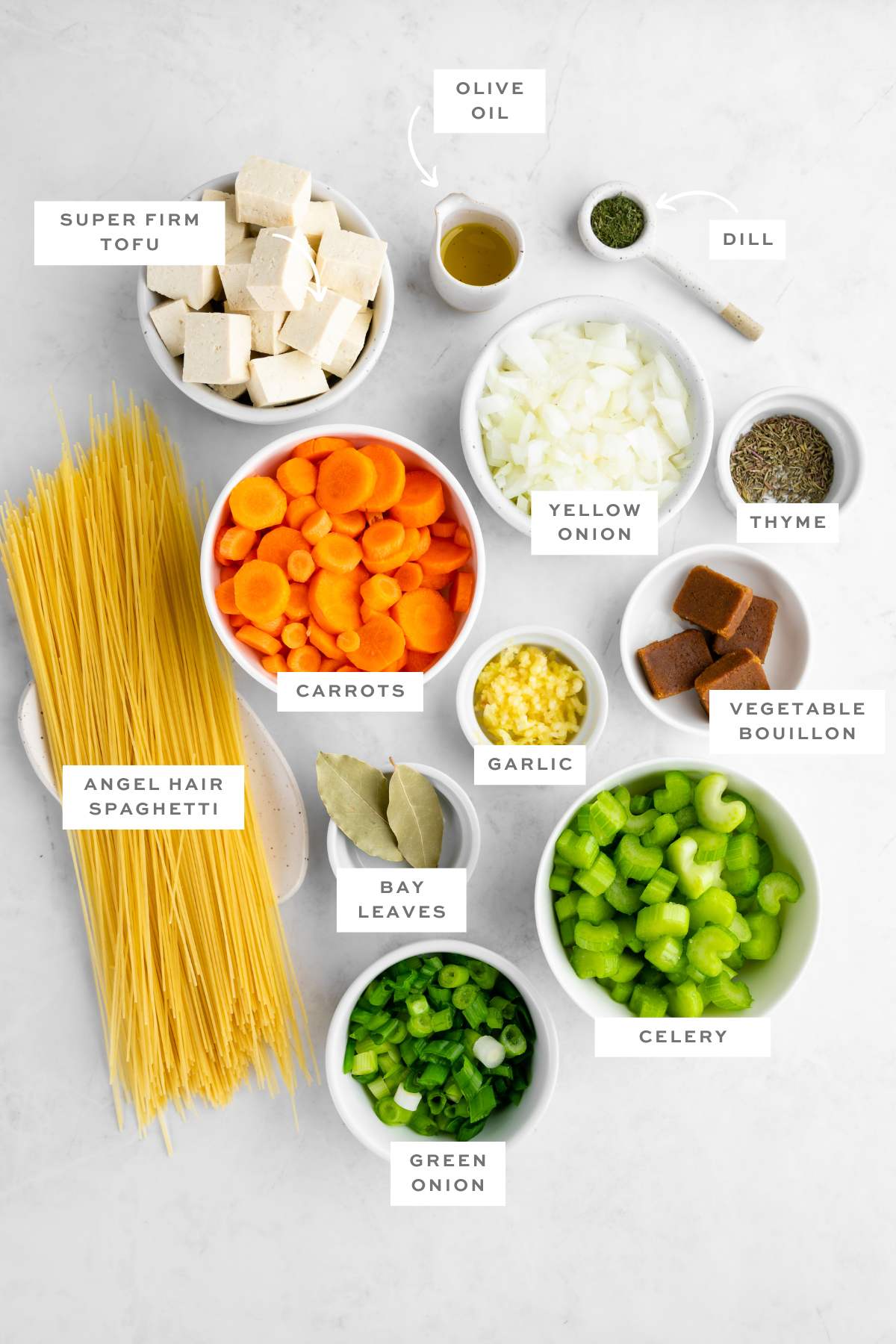 Gathered ingredients for this vegan chicken noodle soup, measured out in individual containers with labels.