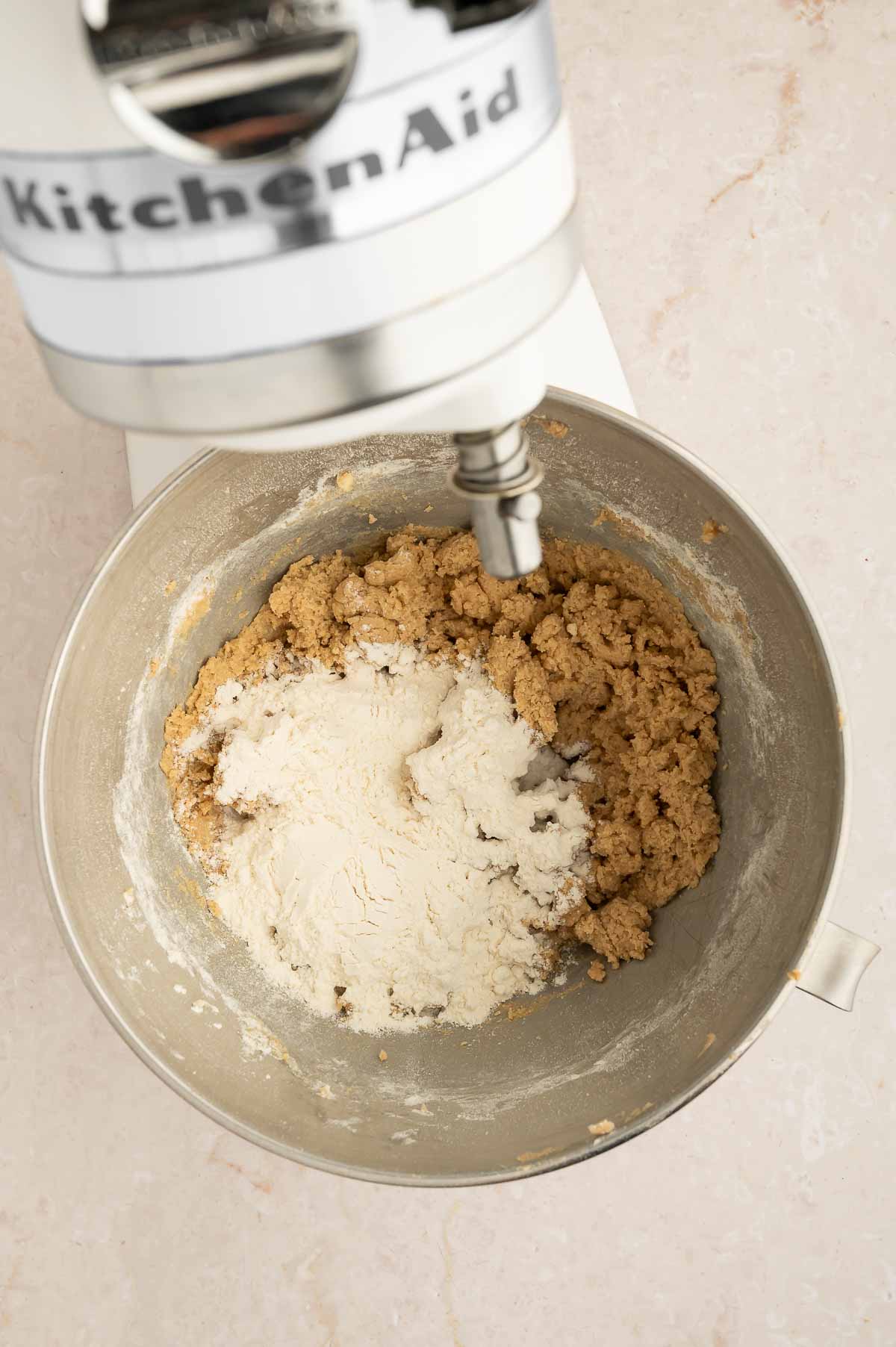 Vegan chai cookie dough in a stand mixer with flour.