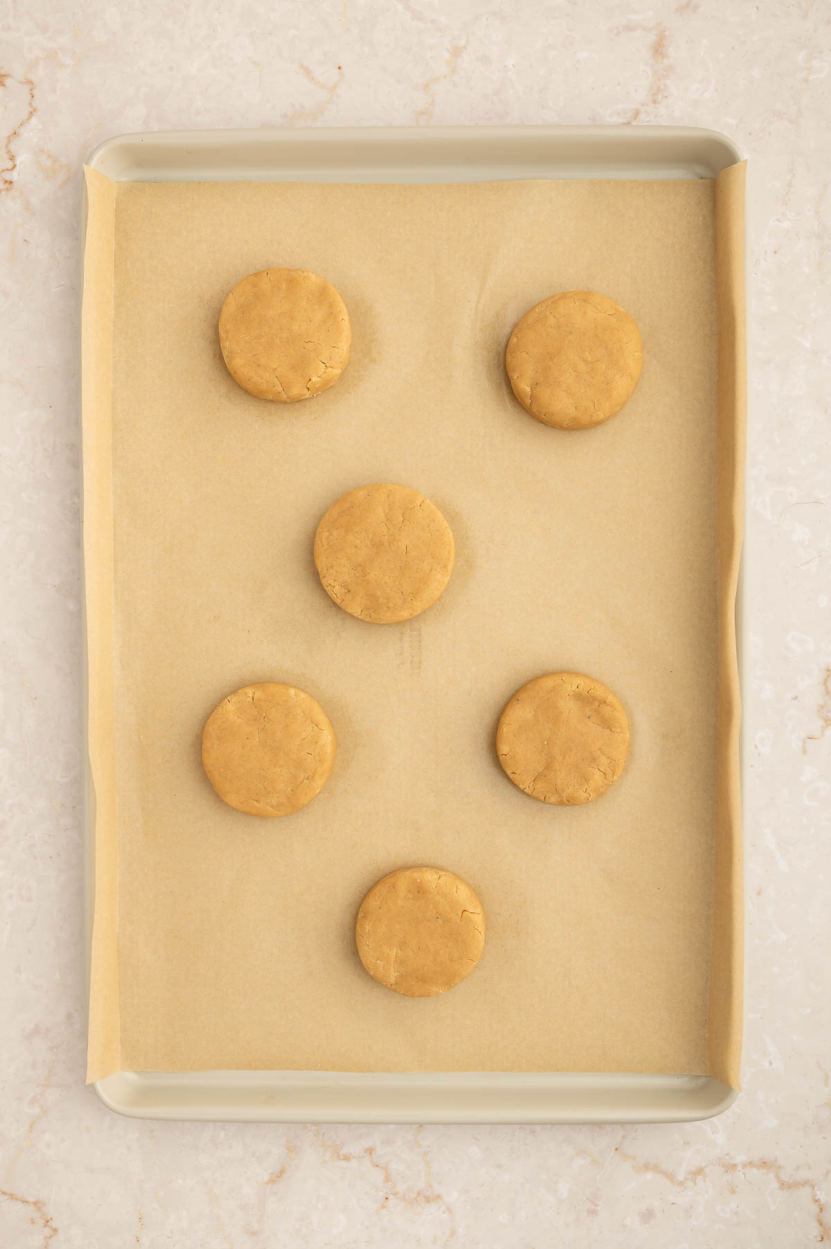 Vegan chai cookies formed but unbaked on a baking sheet.