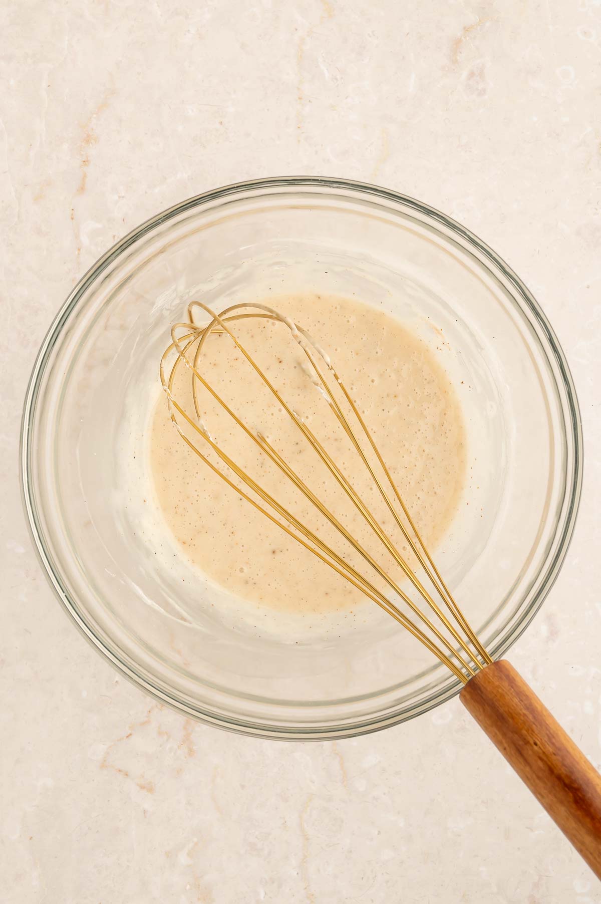 Vegan chai icing in a bowl with a whisk.