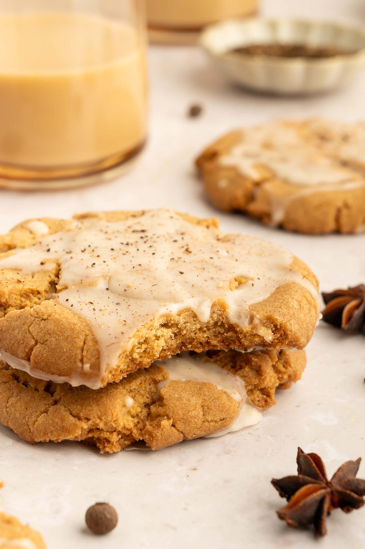 A stack of iced vegan chai tea cookies with a bite taken out.