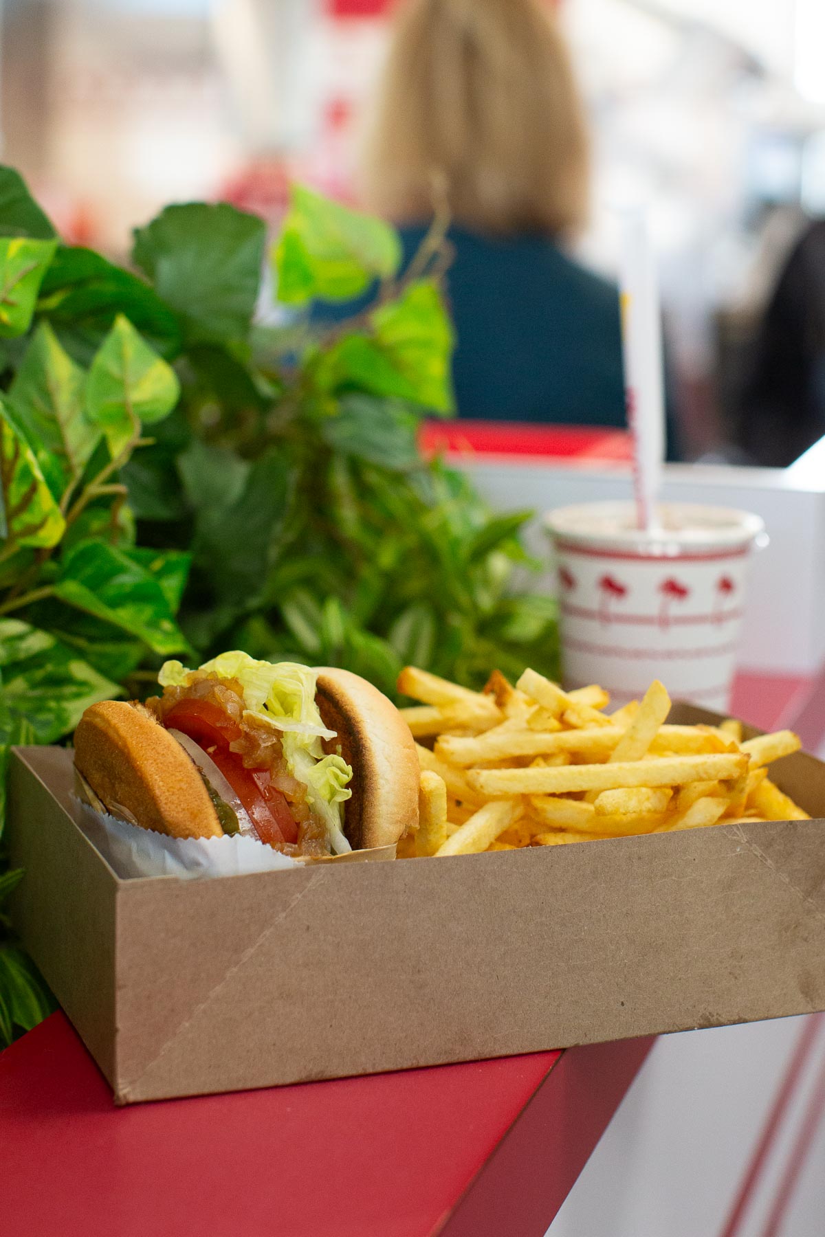 A photo of the best vegan menu options at In N Out Burger including a veggie burger without a patty, fries, and a drink. 