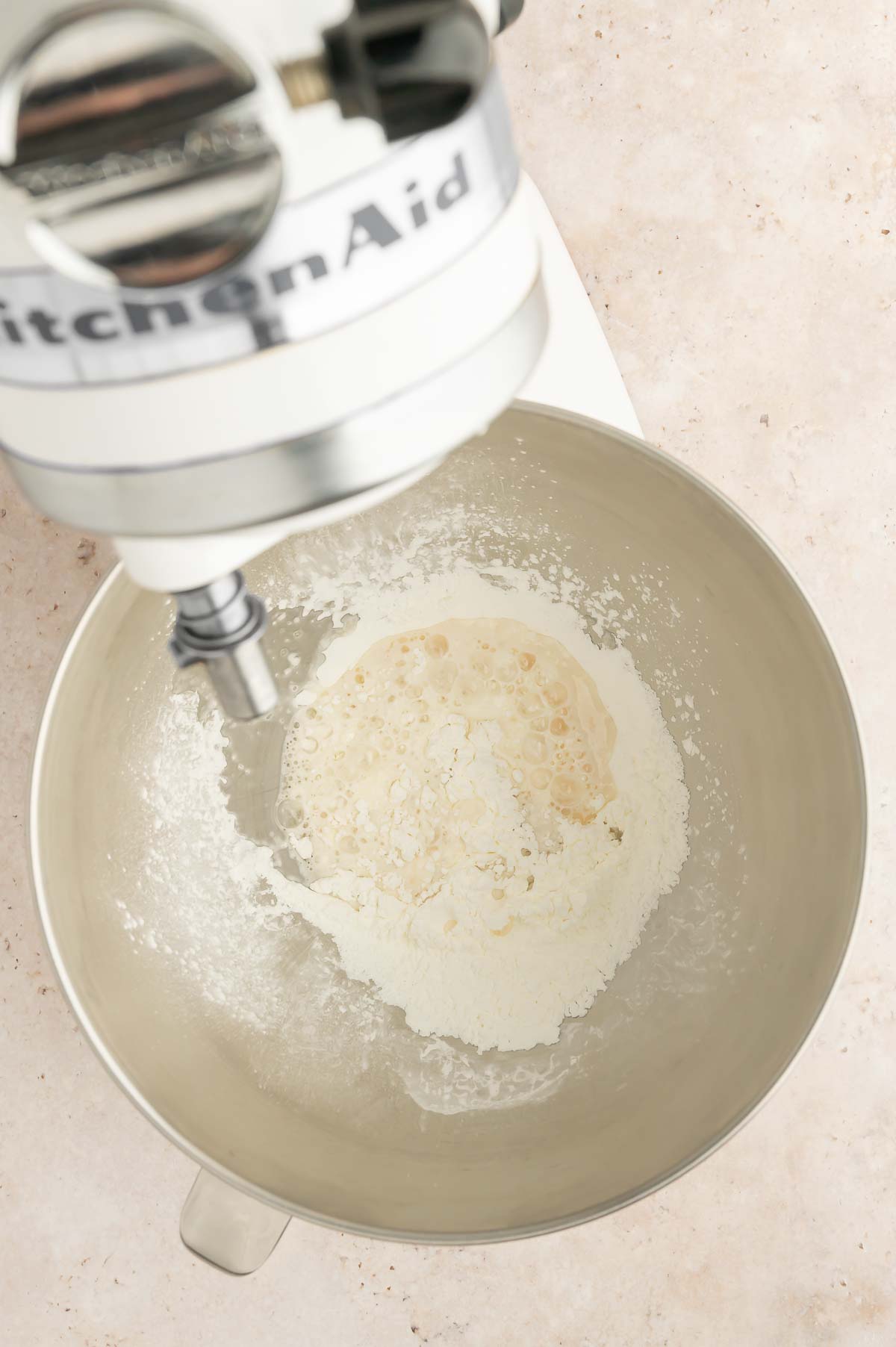 Dry ingredients and canola oil combined in a stand mixer bowl before blending.