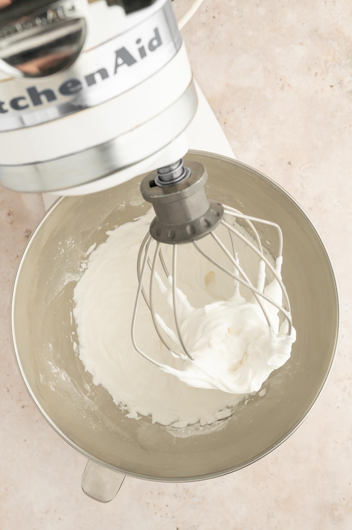 Aquafaba whipped into stiff peaks in a stand mixer to form a vegan meringue.