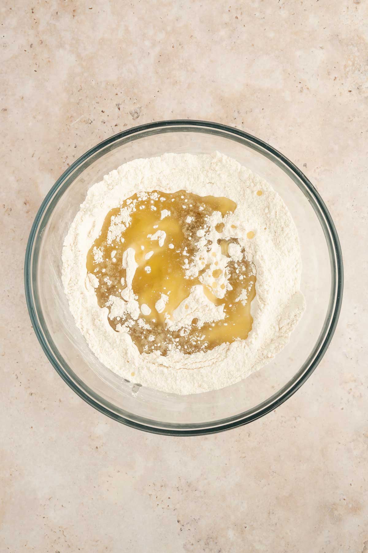 Canola oil poured into flour mixture before mixing for sponge cake batter.